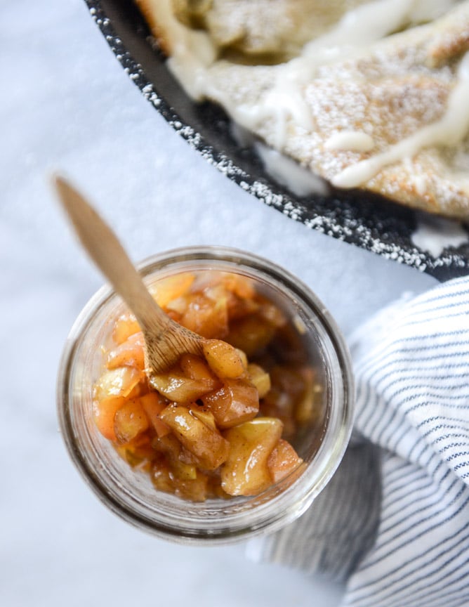 vanilla cinnamon roll dutch baby with apple bourbon compote and cream cheese icing I howsweeteats.com