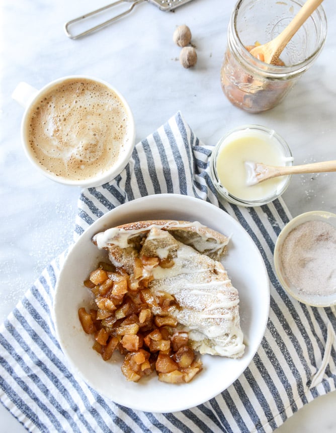 vanilla cinnamon roll dutch baby with apple bourbon compote and cream cheese icing I howsweeteats.com