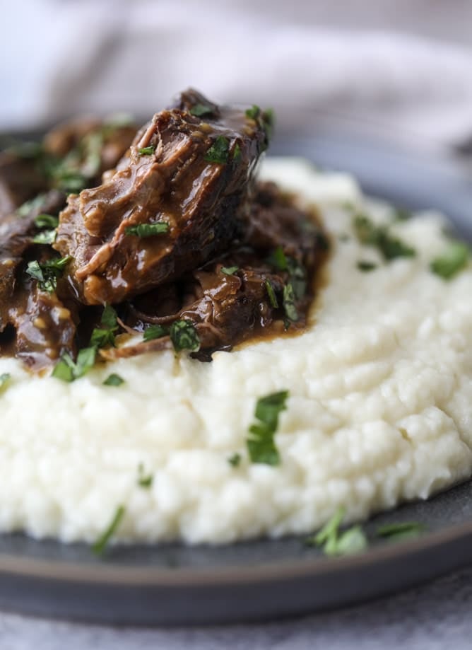 guinness short ribs with cheesy cauliflower mash I howsweeteats.com #slowcooker #guinness #shortribs #saintpatricksday #cauliflower