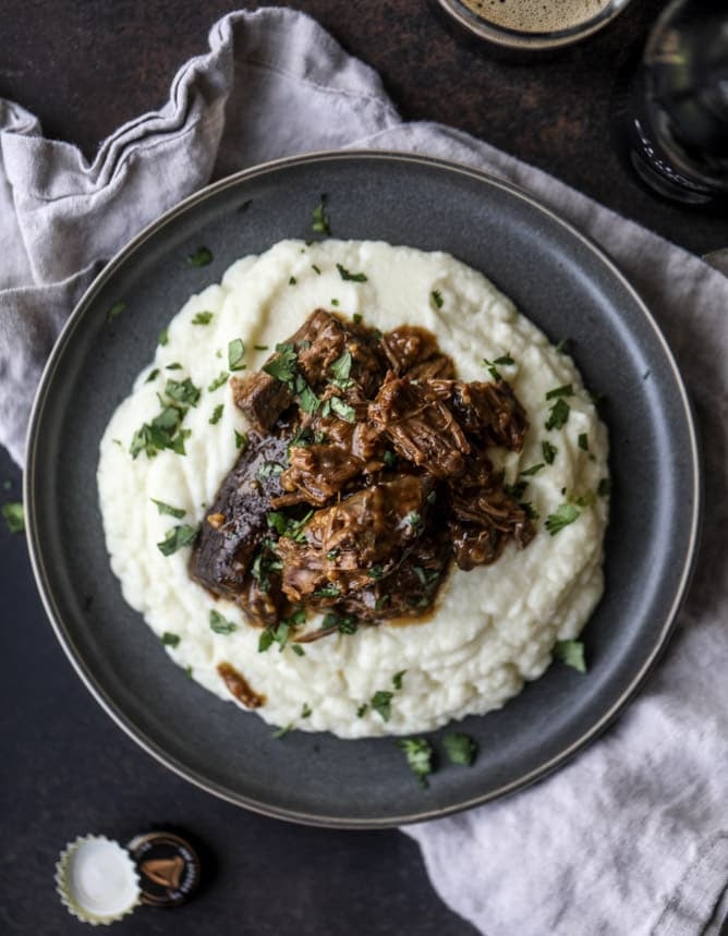 guinness short ribs with cheesy cauliflower mash I howsweeteats.com #slowcooker #guinness #shortribs #saintpatricksday #cauliflower