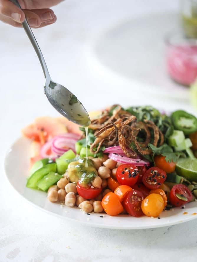 This spicy rainbow salad is chock full of gorgeous, fresh produces, chickpeas, plantains and herbs for one beautiful sight in a bowl. The rainbow salad is satisfying, filling, delicious with a touch of sweet and slightly spicy - everything you want in a meal! I howsweeteats.com #spicy #rainbow #salad