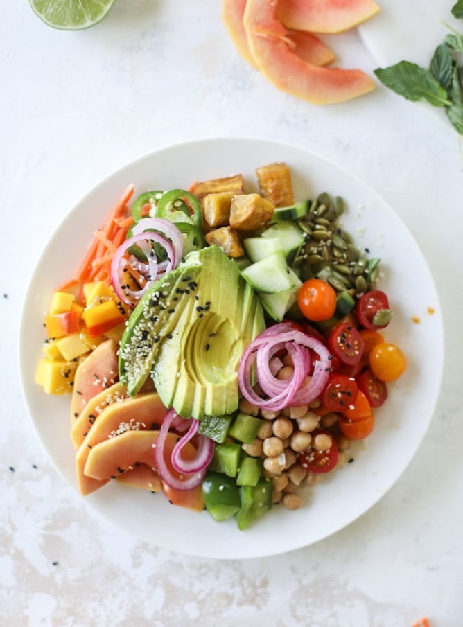 This spicy rainbow salad is chock full of gorgeous, fresh produces, chickpeas, plantains and herbs for one beautiful sight in a bowl. The rainbow salad is satisfying, filling, delicious with a touch of sweet and slightly spicy - everything you want in a meal! I howsweeteats.com #spicy #rainbow #salad