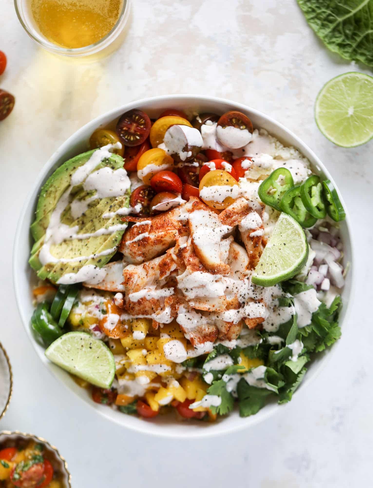 These fish taco bowls are an amazing weeknight meal idea! Napa cabbage for the base, a homemade chipotle crema, avocado, mango pico de gallo, spicy broiled white fish and lots of lime. Major flavor explosion and so easy too! I howsweeteats.com #fish #taco #bowls #spicy #healthy #dinner