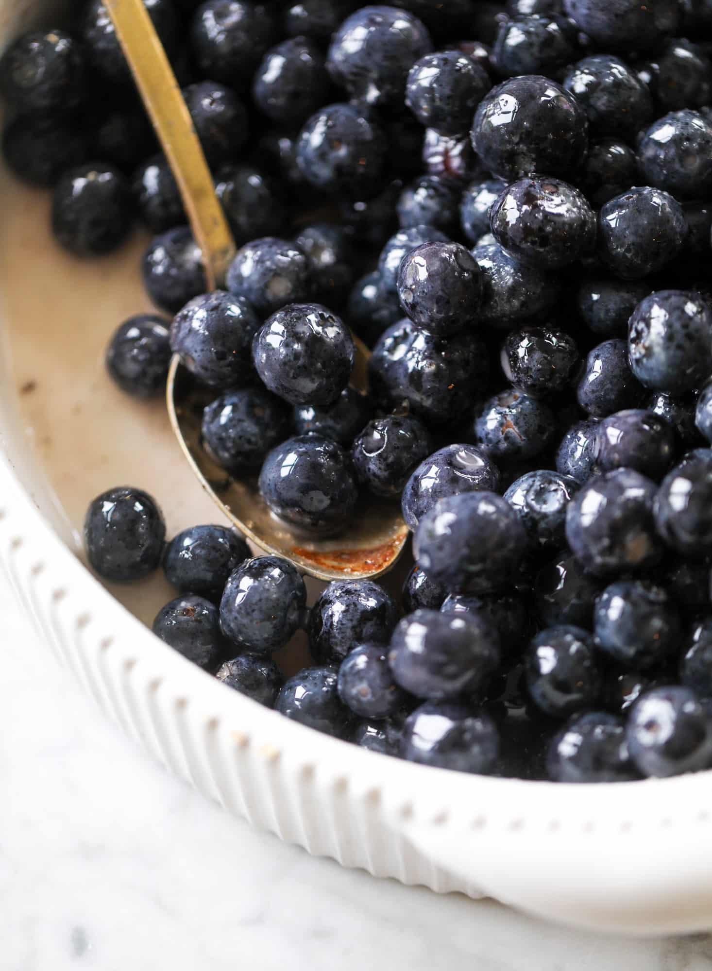 This blueberry crisp is warm and bursting with sweet and juicy fruit. It's topped with a quinoa oatmeal brown sugar topping and is the perfect dessert for summer. Served warm and topped with vanilla ice cream, it's just divine! I howsweeteats.com #blueberry #crisp #quinoa #oats #dessert #fruit
