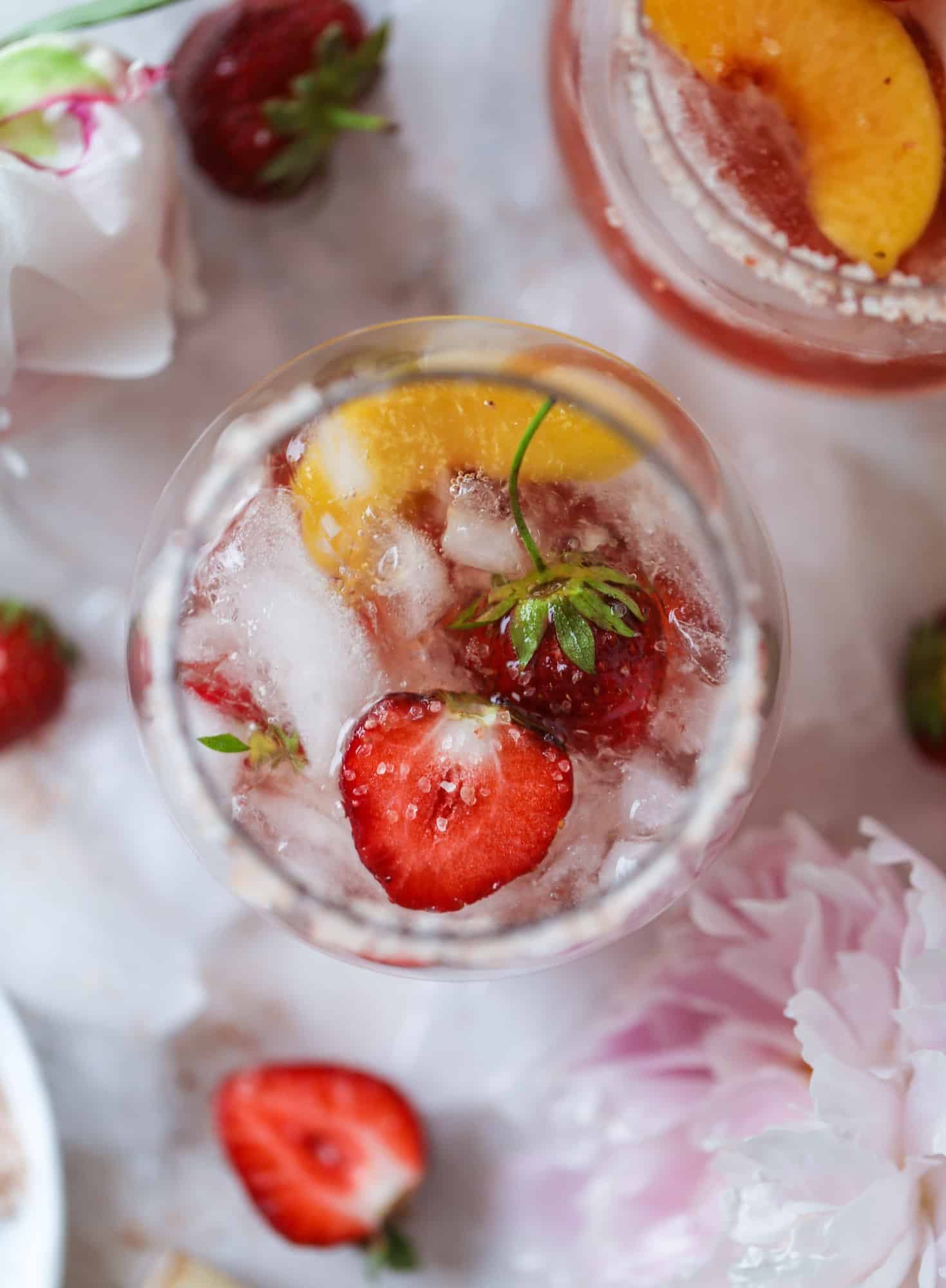 This tequila rosé spritz cocktail is perfectly refreshing for hot summer nights. A mix between a margarita and spritzer, this starts with muddled strawberries and honey, a shot of tequila and is topped off with your favorite rosé wine! I howsweeteats.com #tequila #rosé #wine #spritz #cocktail #strawberries