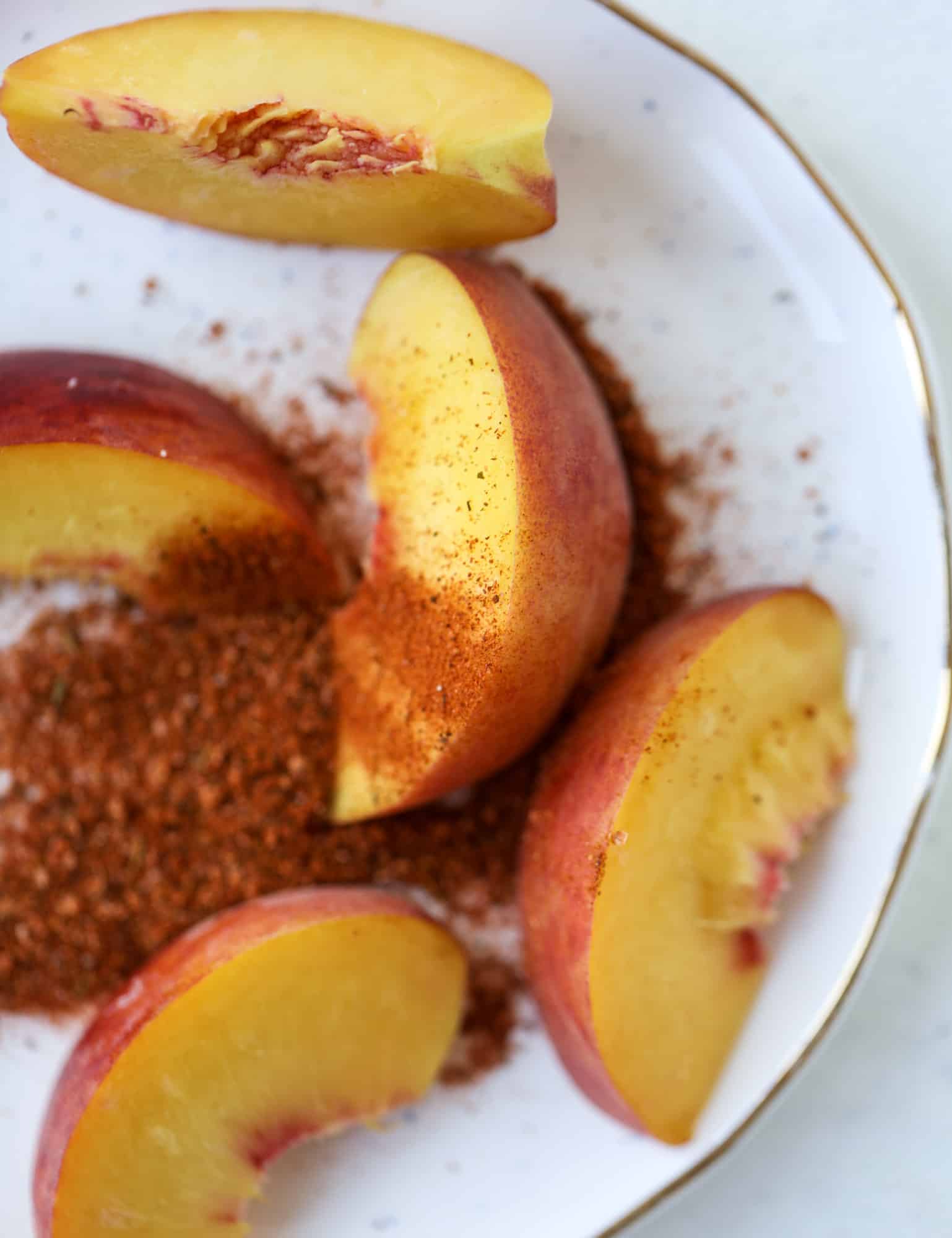 This peach lemonade is super refreshing and a bit spicy for a hot and sunny summer day. It's sweet and fresh and the rim is dipped in a cajun seasoning, bringing the best bite of heat to this perfect summer drink. So fresh! I howsweeteats.com #peach #lemonade #cajun #summer #mocktail #lemon #drink