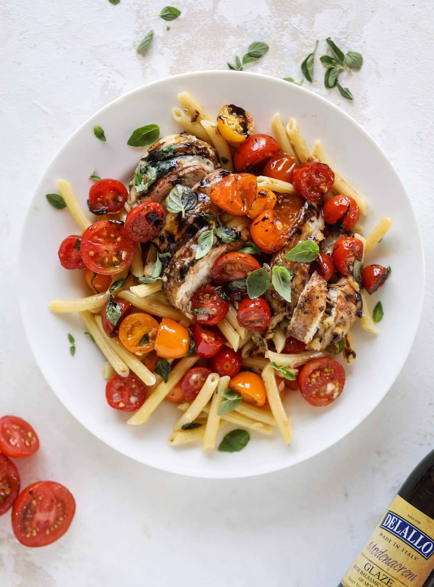 This bruschetta chicken is the perfect summer garden meal! Juicy, flavorful chicken topped with fresh tomatoes, garlic, basil and balsamic glaze, along with a touch of cheese. Served with pasta, it's an incredible meal. I howsweeteats.com #bruschetta #chicken #pasta #tomatoes #basil