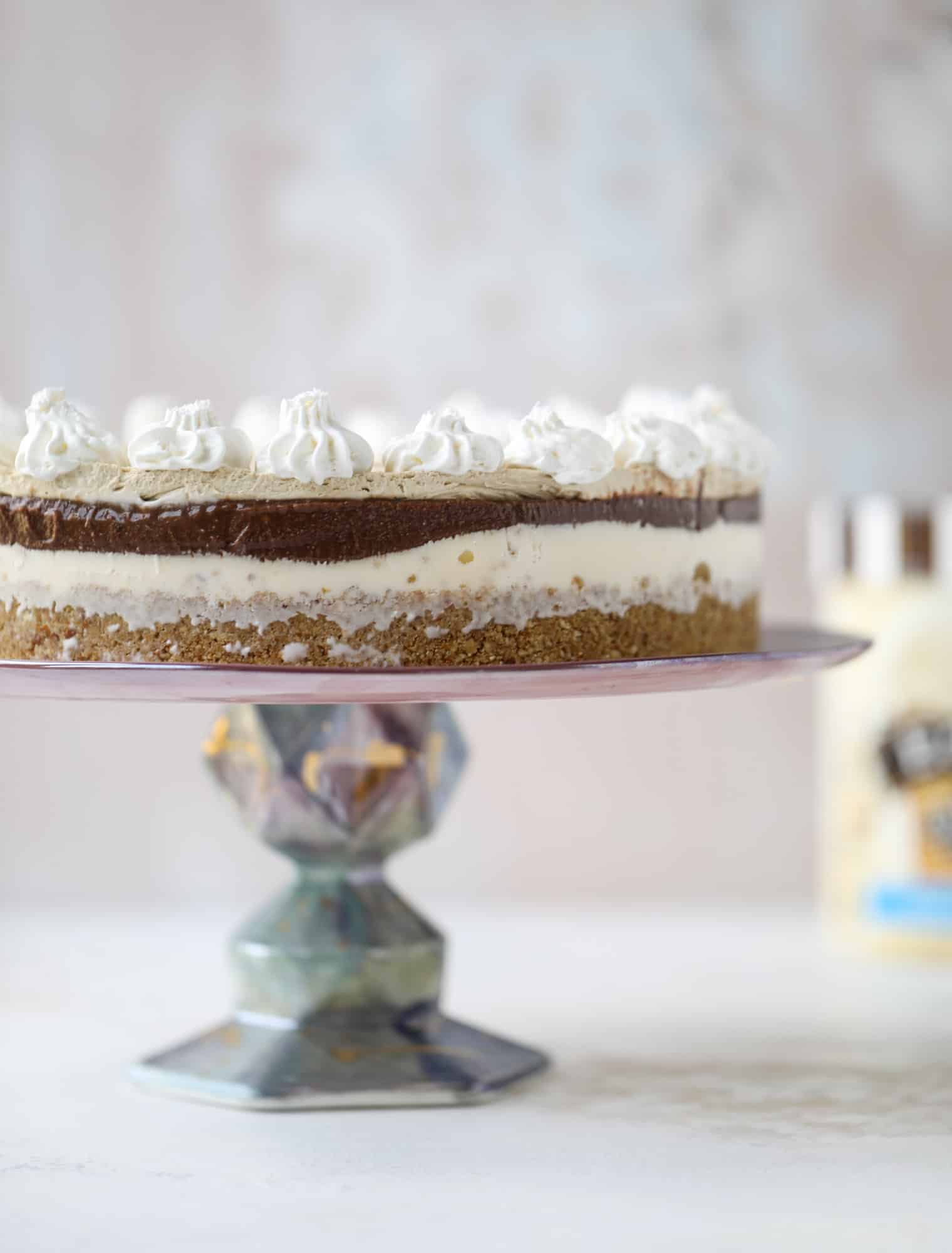 This peanut butter fudge ice cream cake is absolutely insane and perfect for summer! A sweet and savory pretzel crust, vanilla ice cream, homemade hot fudge and a peanut butter whipped cream layer take it to the next LEVEL. Delicious! I howsweeteats.com #icecream #cake #peanutbutter #chocolate #pretzel