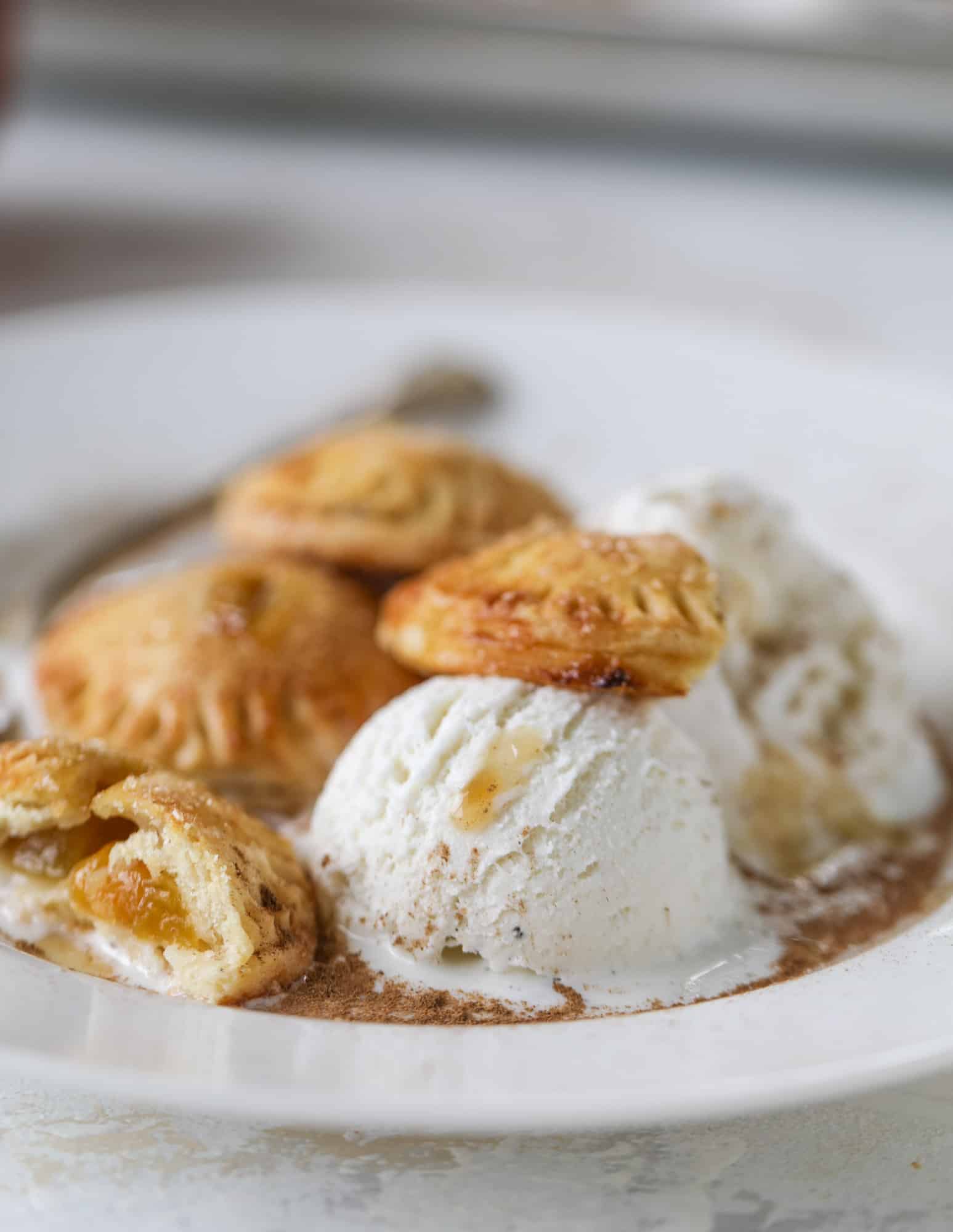 These little peach hand pies are super easy to make and oh-so delicious for summer! A warm and syrupy homemade peach filling made with brown sugar and bourbon, stuck inside a flakey all-butter crust and sprinkled with coarse sugar. SO GOOD. I howsweeteats.com #peach #hand #pies #mini #dessert #summer
