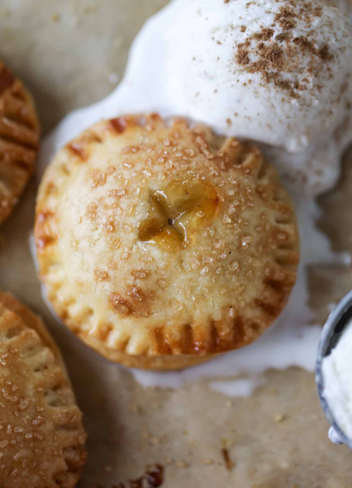 These little peach hand pies are super easy to make and oh-so delicious for summer! A warm and syrupy homemade peach filling made with brown sugar and bourbon, stuck inside a flakey all-butter crust and sprinkled with coarse sugar. SO GOOD. I howsweeteats.com #peach #hand #pies #mini #dessert #summer