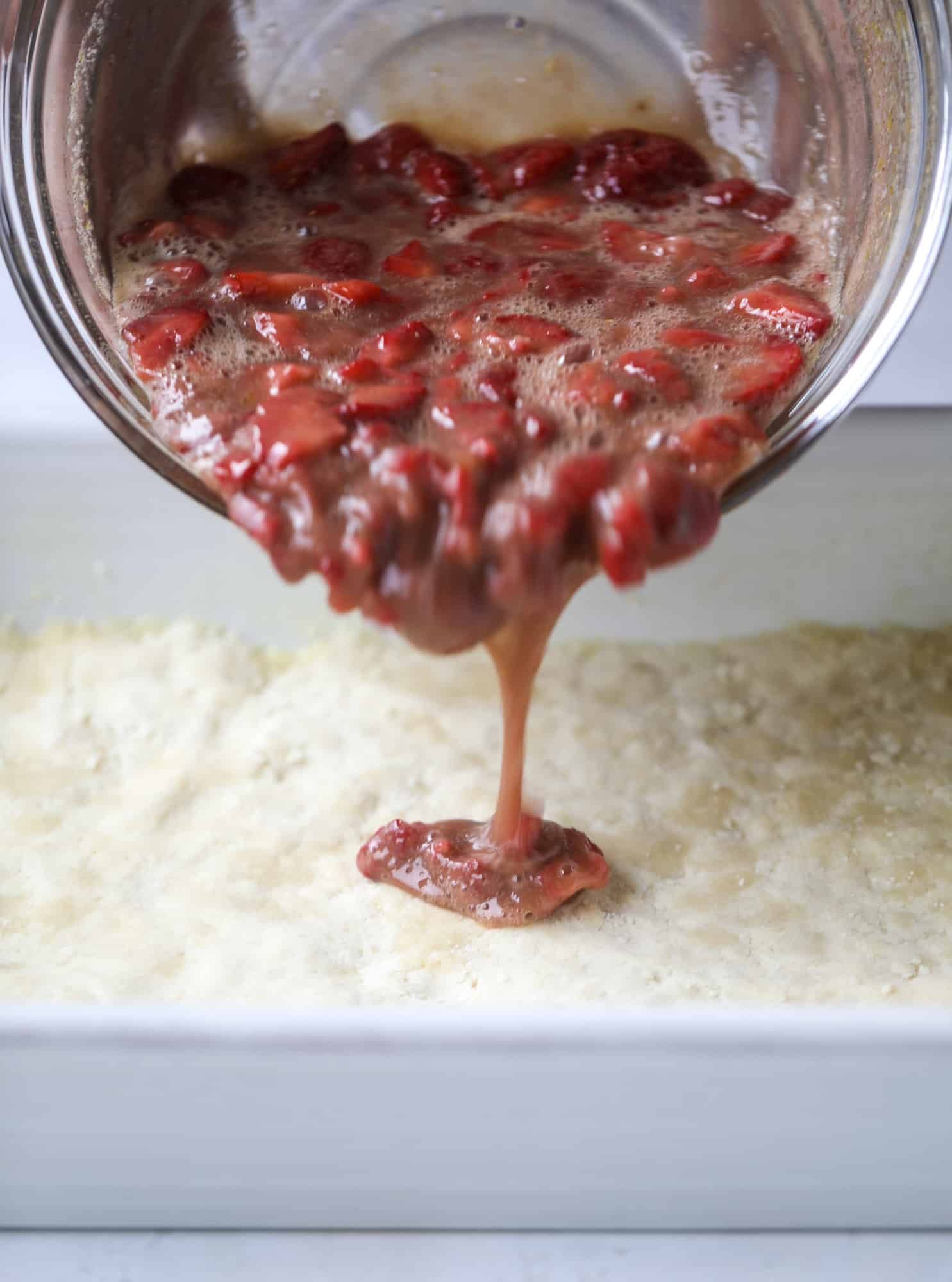 These strawberry cobbler bars are super delicious and perfect for a crowd! Made with juicy fresh strawberries, they start with a shortbread crust and end with a crumbly topping with a warm and delicious fruity filling. Huge hit! I howsweeteats.com #strawberry #cobbler #bars