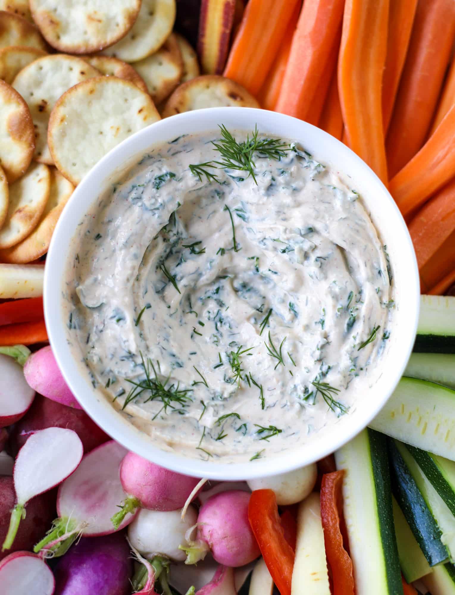 This greek yogurt ranch dip is fabulous for a summertime pool tip and it's full of greens! Made with a homemade ranch spice seasoning, lots of shredded greek kale and greek yogurt, it's the perfect dip for crudite or chips! I howsweeteats.com #kale #greek #yogurt #ranch #dip #healthy #snacks
