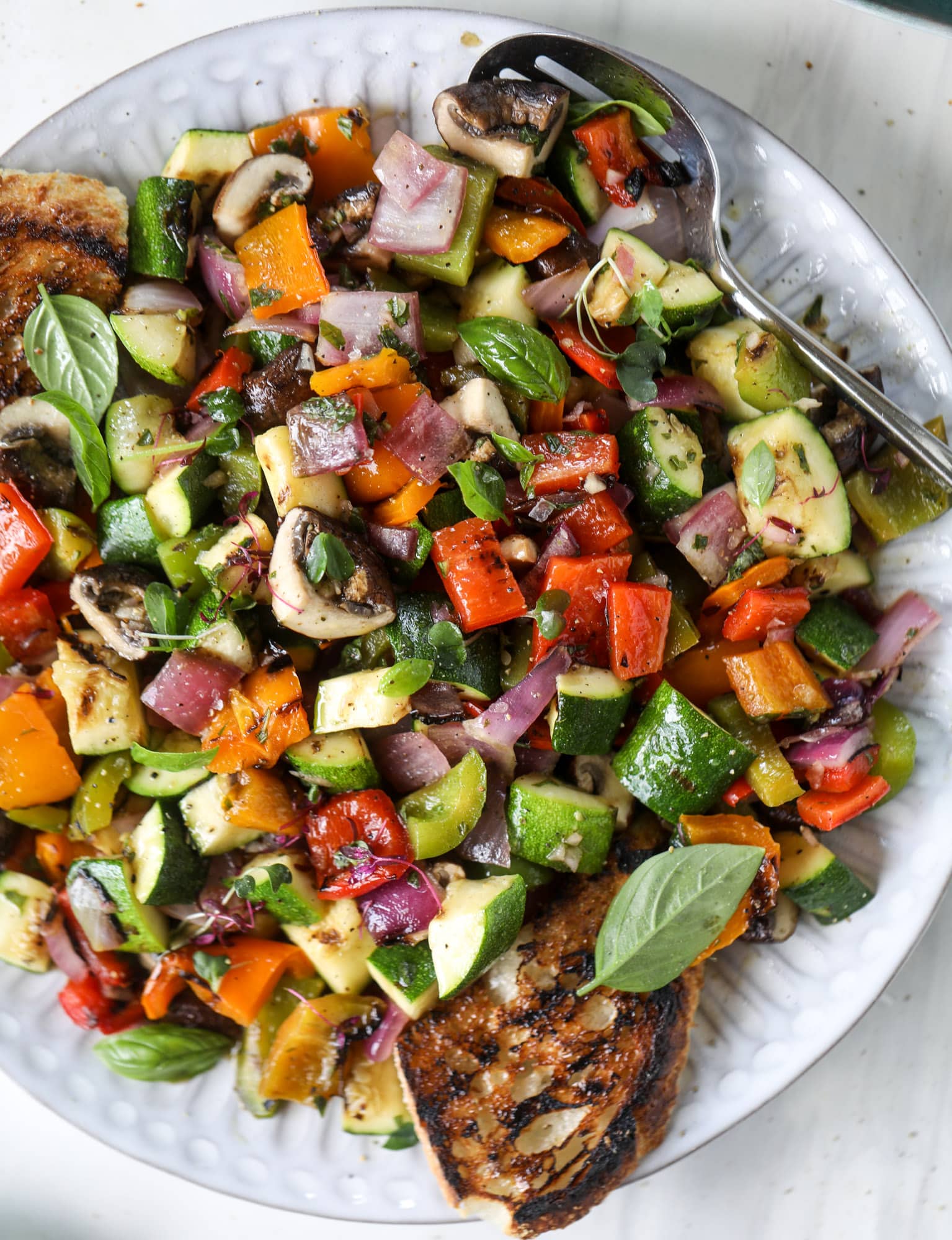 These are the best grilled vegetables ever! You grill your veggies and chop them into the perfect bite, then drizzle them with a fabulous fresh basil vinaigrette. Delish! It doesn't end there; serve these with grilled garlic toast and everyone will freak! I howsweeteats.com #best #grilled #vegetables #veggies #basil #bread