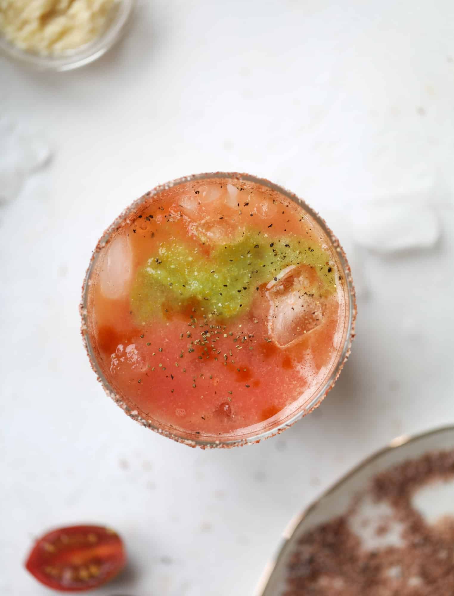 This bloody mary recipe is made with fresh heirloom tomatoes - the gems of summer! The colors swirl together to create a stunning drinking that is loaded with smoky, spicy flavor. Top with your favorite snacks foe the perfect brunch! I howsweeteats.com #bloody #mary #recipe #best #heirloom #tomatoes #cocktail