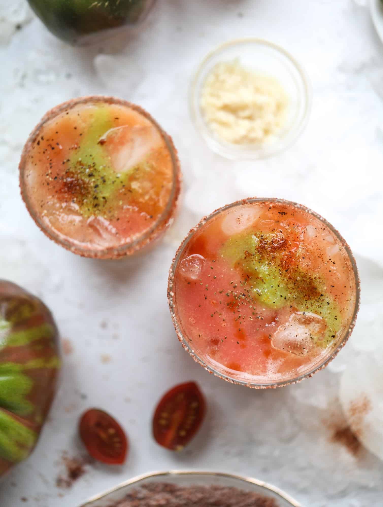 This bloody mary recipe is made with fresh heirloom tomatoes - the gems of summer! The colors swirl together to create a stunning drinking that is loaded with smoky, spicy flavor. Top with your favorite snacks foe the perfect brunch! I howsweeteats.com #bloody #mary #recipe #best #heirloom #tomatoes #cocktail