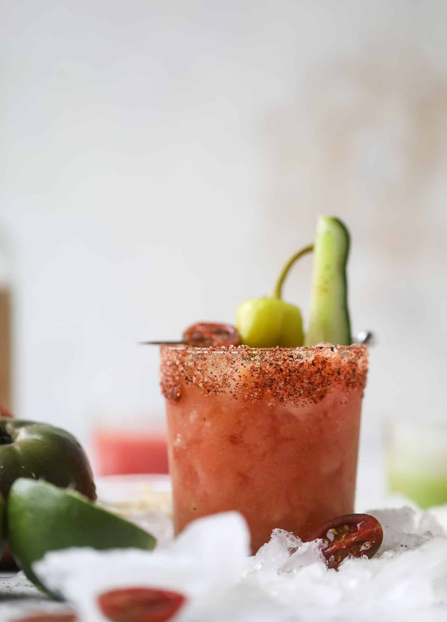 This bloody mary recipe is made with fresh heirloom tomatoes - the gems of summer! The colors swirl together to create a stunning drinking that is loaded with smoky, spicy flavor. Top with your favorite snacks foe the perfect brunch! I howsweeteats.com #bloody #mary #recipe #best #heirloom #tomatoes #cocktail