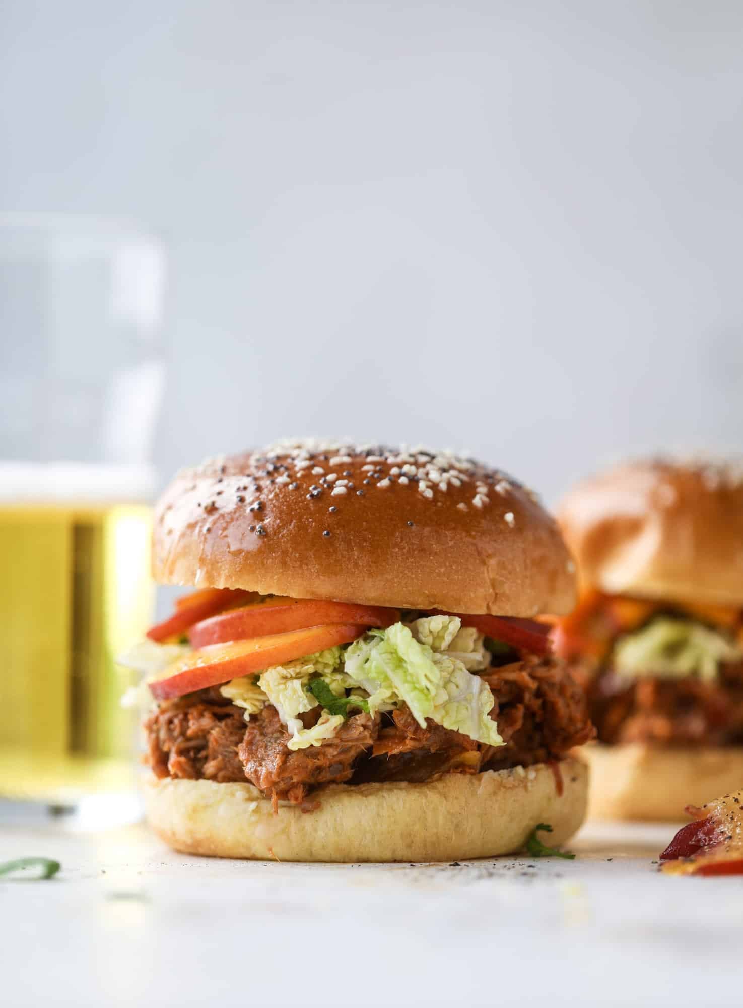 This chipotle pulled pork sandwich is spicy, sweet and saucy. Throw it on a bun or a plate and top it with the most delicious quick pickled peaches and napa cabbage slaw. Flavor and texture make this sandwich incredible! I howsweeteats.com #pulled #pork #chipotle #pickled #peaches #slaw #sandwiches #slow #cooker