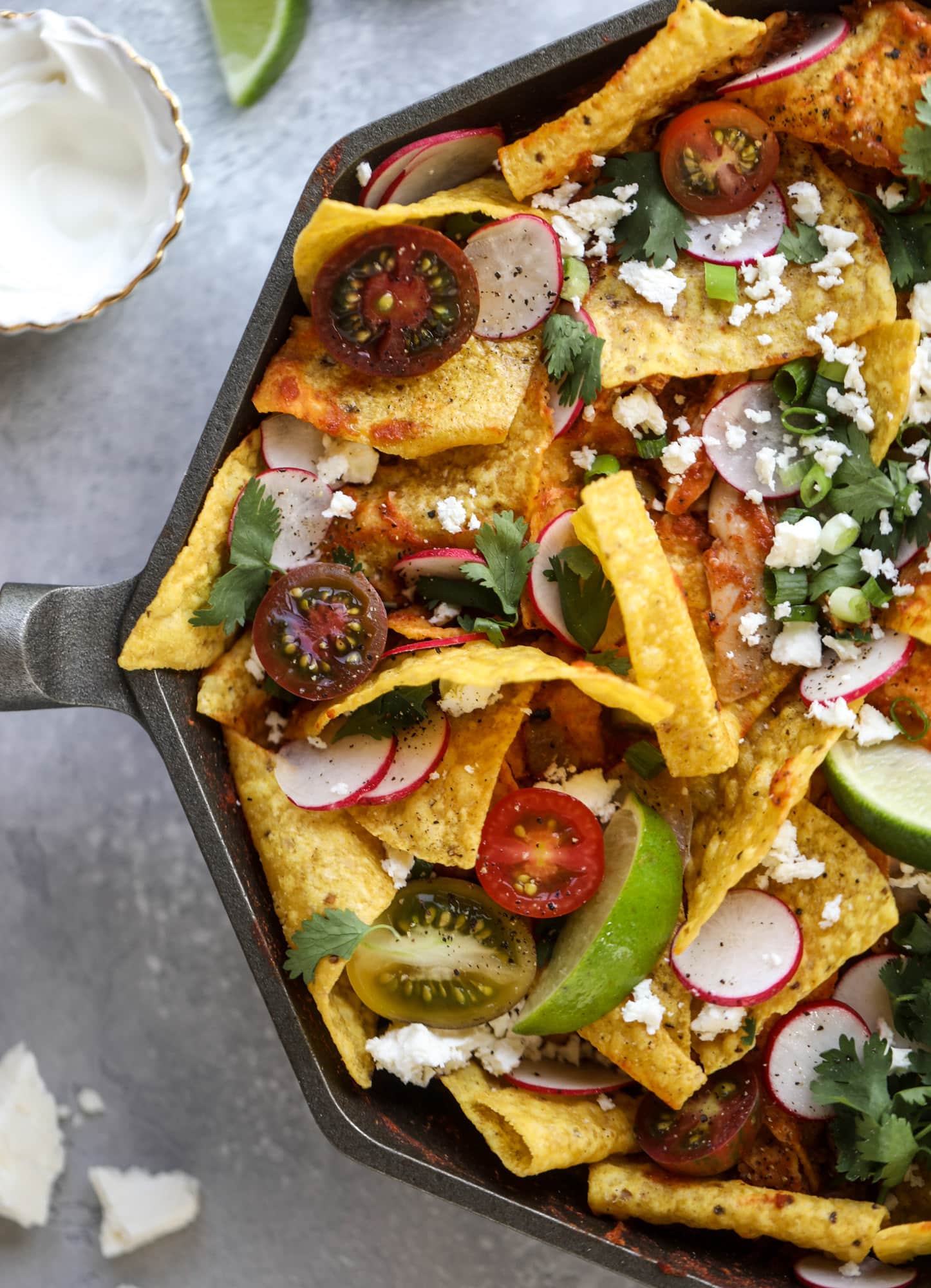 This skillet of fire roasted chicken chilaquiles is so easy, flavorful and delicious! A quick blender sauce made with fire roasted tomatoes, shredded chicken, lots of tortilla chips and your favorite toppings. Give me all the cheese and guacamole! I howsweeteats.com #chicken #chilaquiles #recipe #easy #dinner