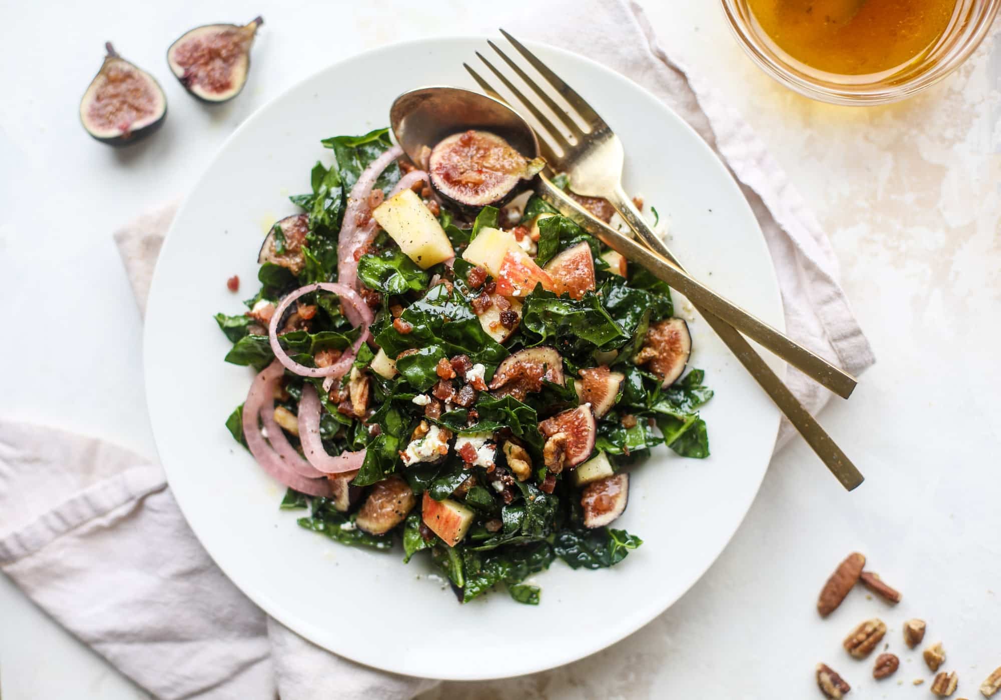 This fall kale salad is perfect for the season and full of so much delicious flavor! Shredded kale, honeycrisp apple, fresh figs, pancetta, pickled onions, pecans and goat cheese come together with a maple cider vinaigrette for salad heaven. I howsweeteats.com #fall #kale #salad #apples #figs #pecans