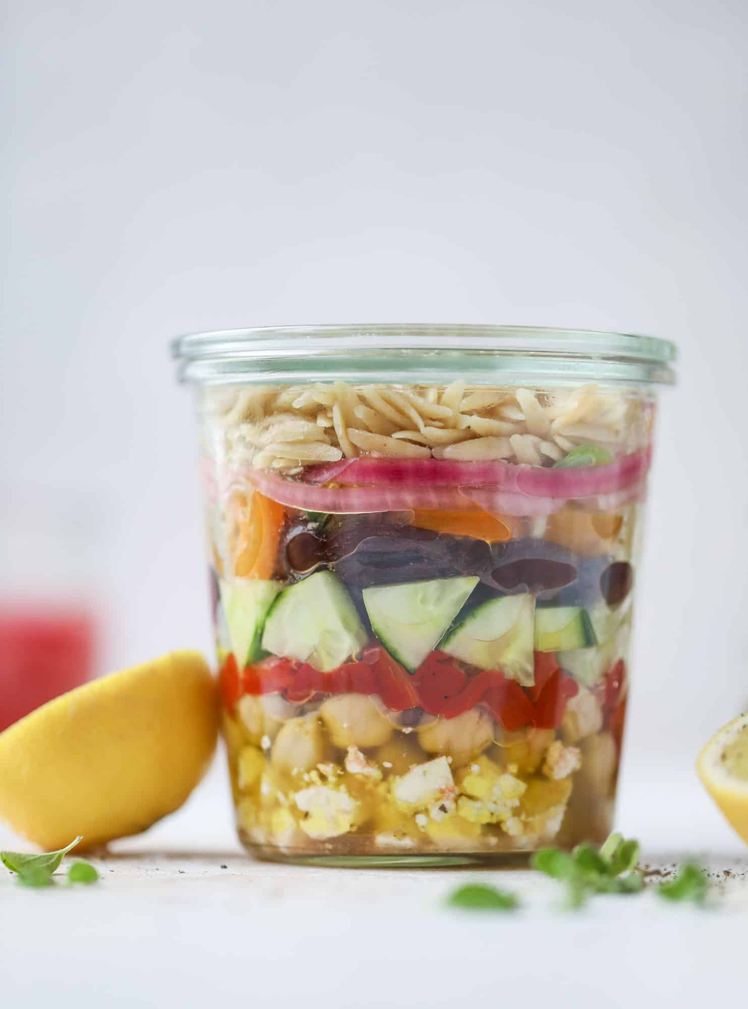 This incredible greek orzo salad in a jar is to die for! The recipe is so easy and flavorful, super satisfying and perfect for meal prep. This salad in a jar is a delicious lunch idea for the weekdays and keeps you feeling full and happy! I howsweeteats.com #salad #jar #greek #orzo #recipes #healthy #lunch #mealprep
