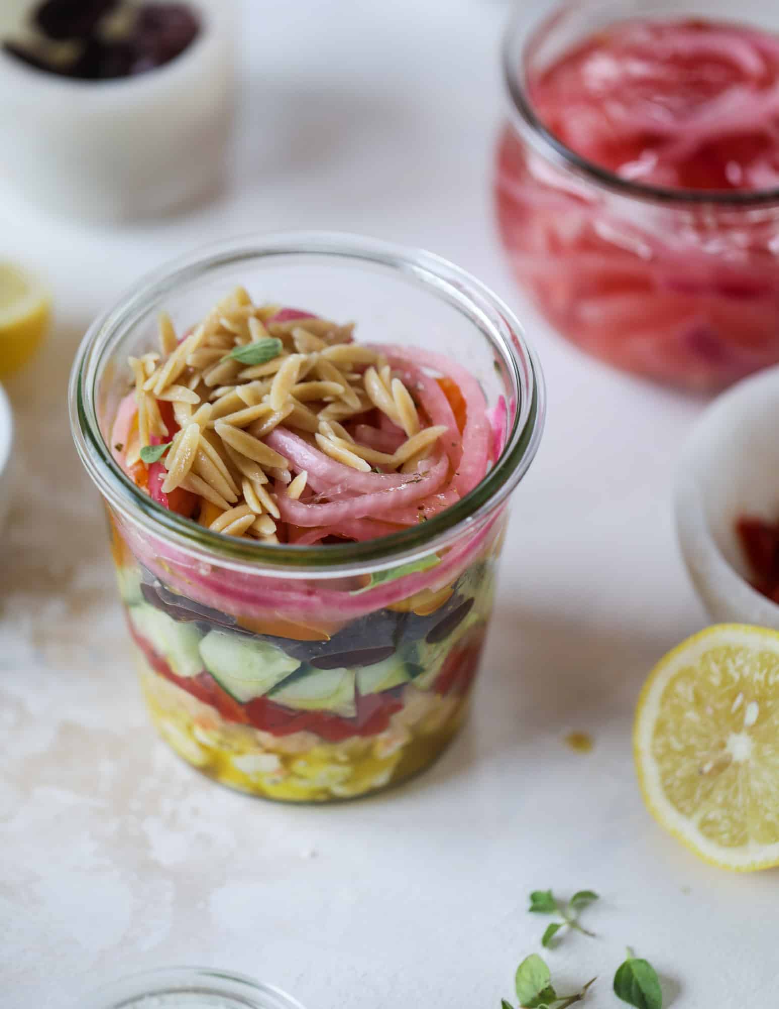 This incredible greek orzo salad in a jar is to die for! The recipe is so easy and flavorful, super satisfying and perfect for meal prep. This salad in a jar is a delicious lunch idea for the weekdays and keeps you feeling full and happy! I howsweeteats.com #salad #jar #greek #orzo #recipes #healthy #lunch #mealprep