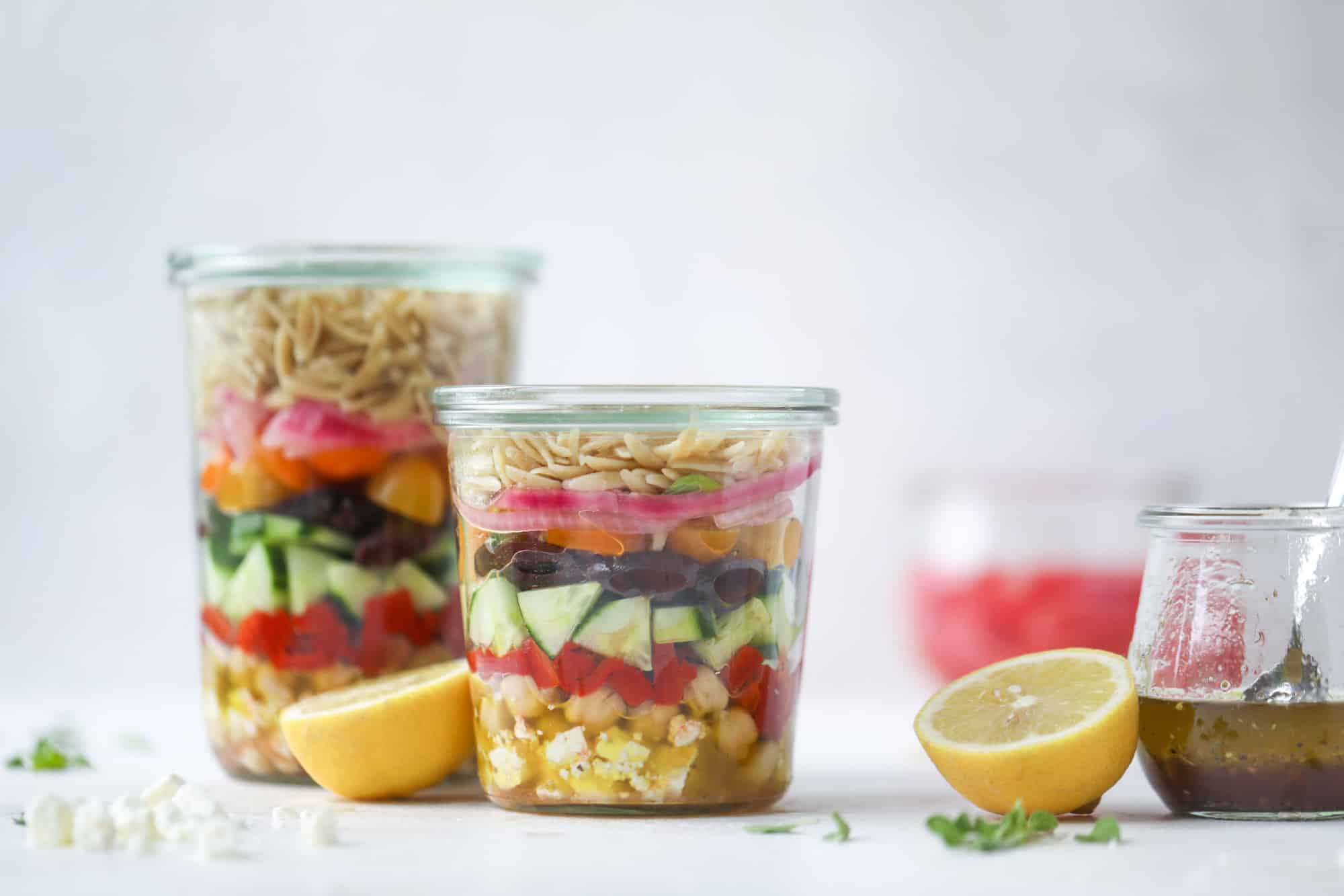 This incredible greek orzo salad in a jar is to die for! The recipe is so easy and flavorful, super satisfying and perfect for meal prep. This salad in a jar is a delicious lunch idea for the weekdays and keeps you feeling full and happy! I howsweeteats.com #salad #jar #greek #orzo #recipes #healthy #lunch #mealprep