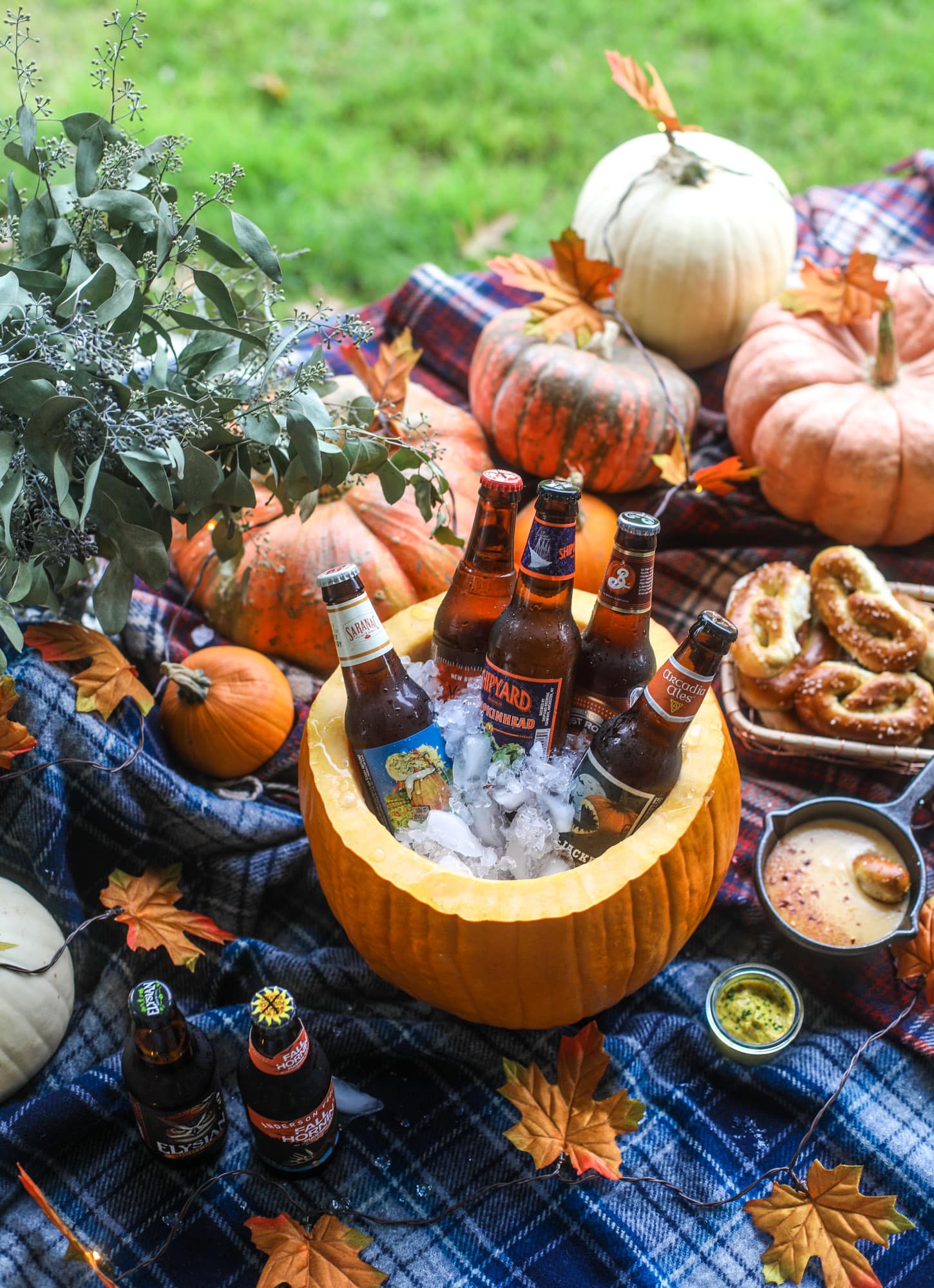 This is the cutest way ever to serve the best pumpkin beer! If you do a pumpkin beer party of a pumpkin beer tasting, this pumpkin cooler is an adorable (and easy!) way to make things festive. Kick it up with a hot pretzel bar and lots of dipping sauce too! I howsweeteats.com #pumpkin #beer #cooler #softpretzel #fall #cheese
