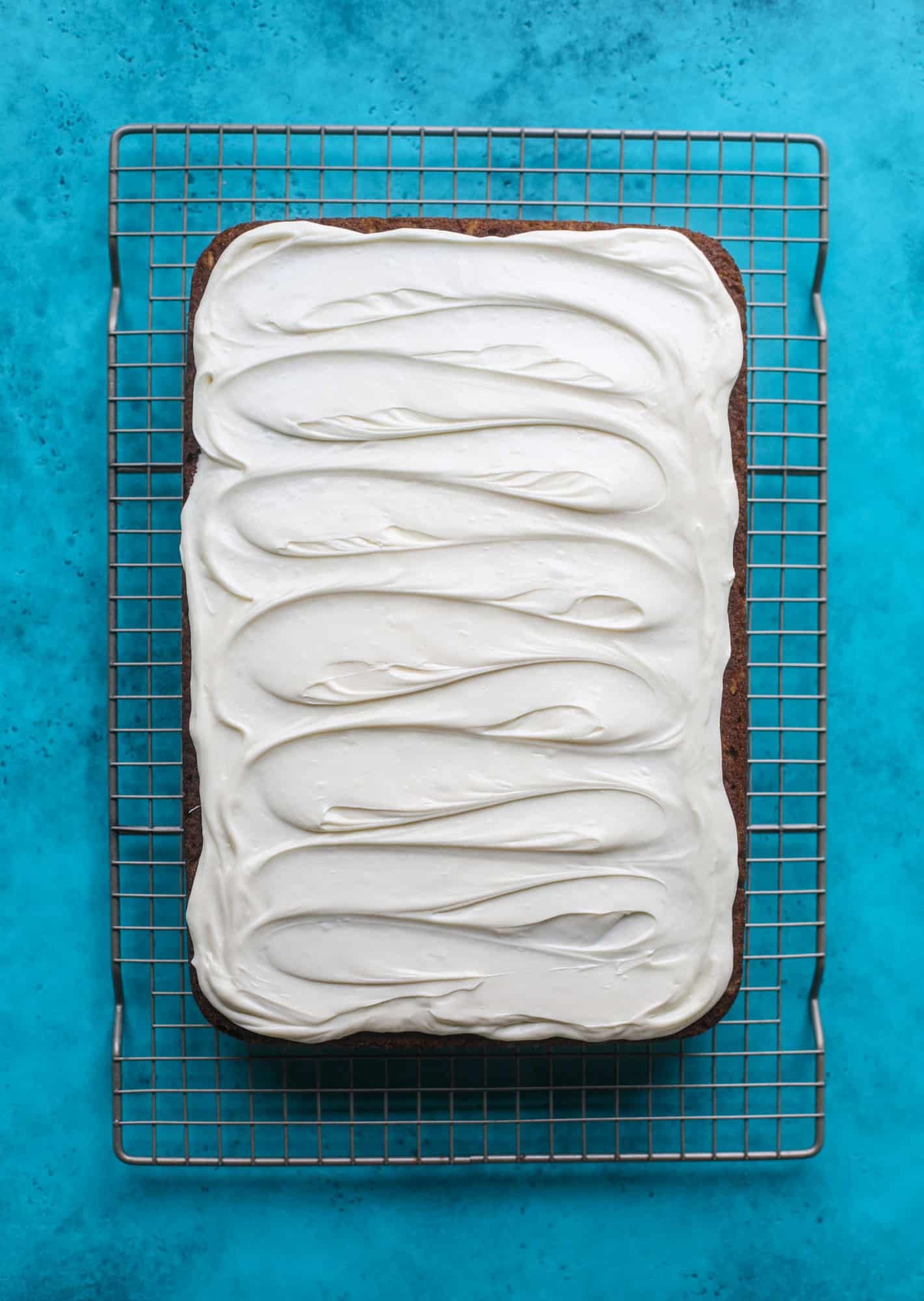 This pumpkin coconut cake is super tender and delicious and comes together quickly in a baking dish! It's spiced for the season and covered in a fluffy coconut cream cheese frosting. You can made it ahead of time for a crowd and it's a huge hit! I howsweeteats.com #pumpkin #cake