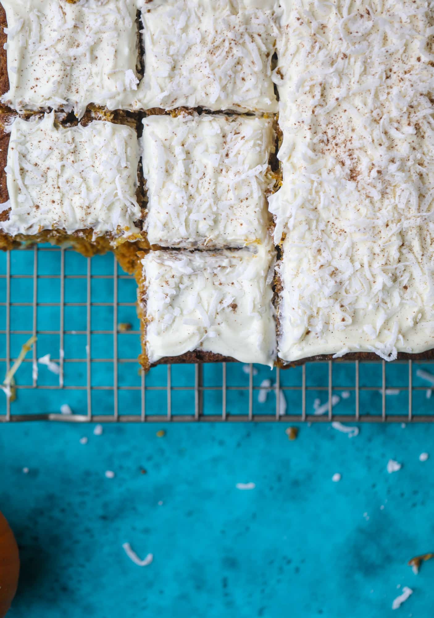 This pumpkin coconut cake is super tender and delicious and comes together quickly in a baking dish! It's spiced for the season and covered in a fluffy coconut cream cheese frosting. You can made it ahead of time for a crowd and it's a huge hit! I howsweeteats.com #pumpkin #cake