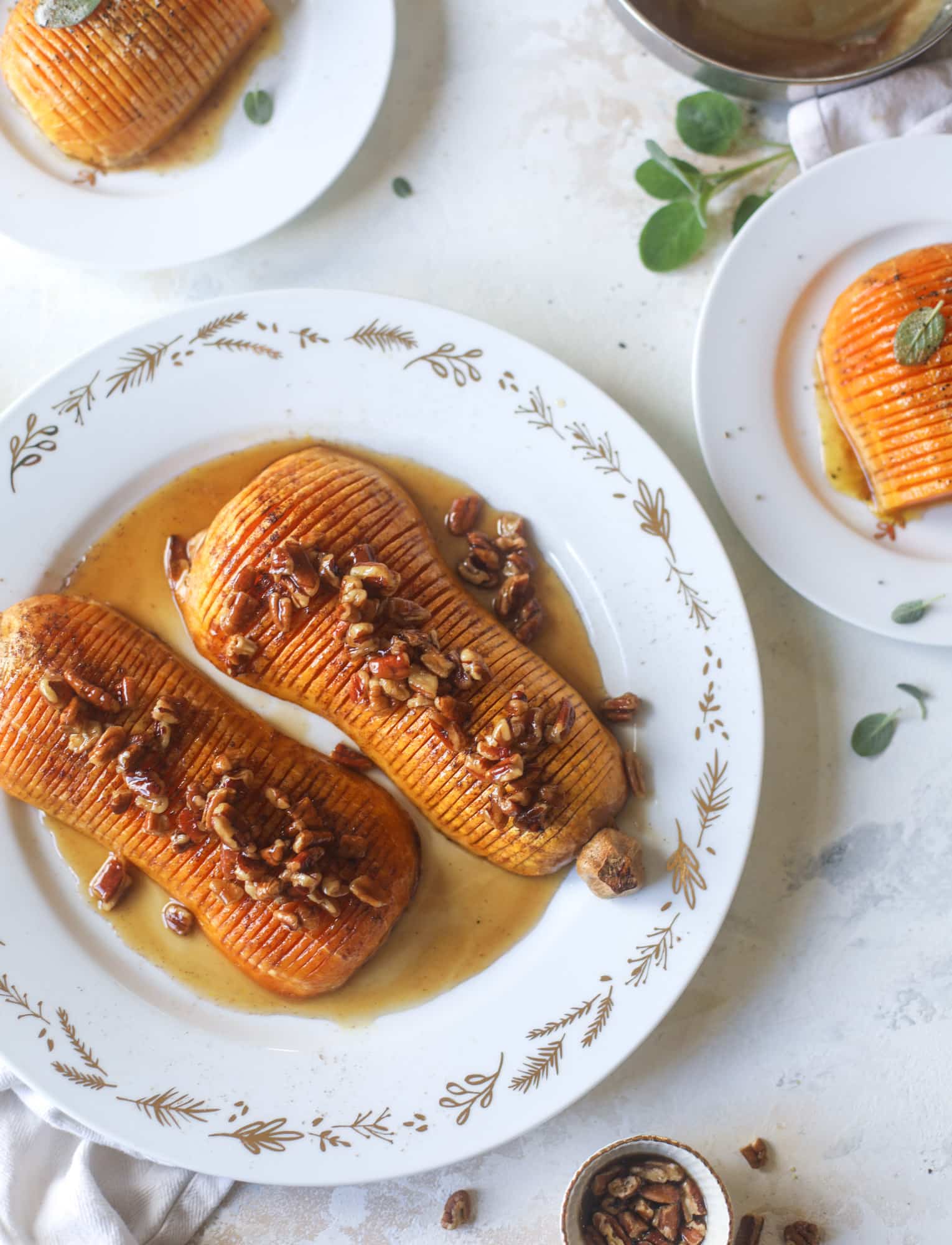 This hasselback butternut squash is perfect for Thanksgiving - and you can easily make it two ways! We have a maple pecan hassleback butternut squash and a brown butter sage hasselback butternut squash. Delicious! I howsweeteats.com #hasselback #butternutsquash