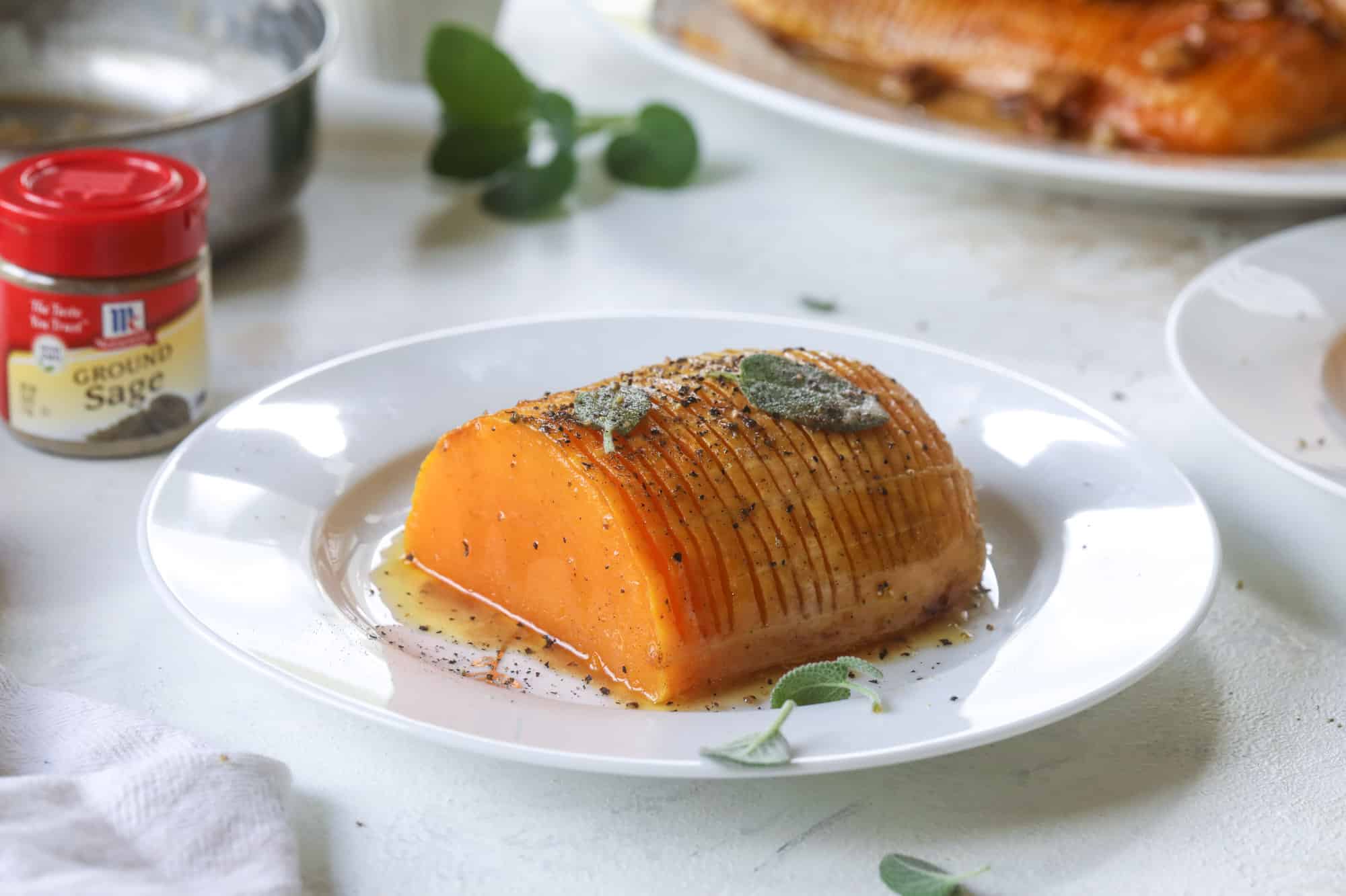 This hasselback butternut squash is perfect for Thanksgiving - and you can easily make it two ways! We have a maple pecan hassleback butternut squash and a brown butter sage hasselback butternut squash. Delicious! I howsweeteats.com #hasselback #butternutsquash