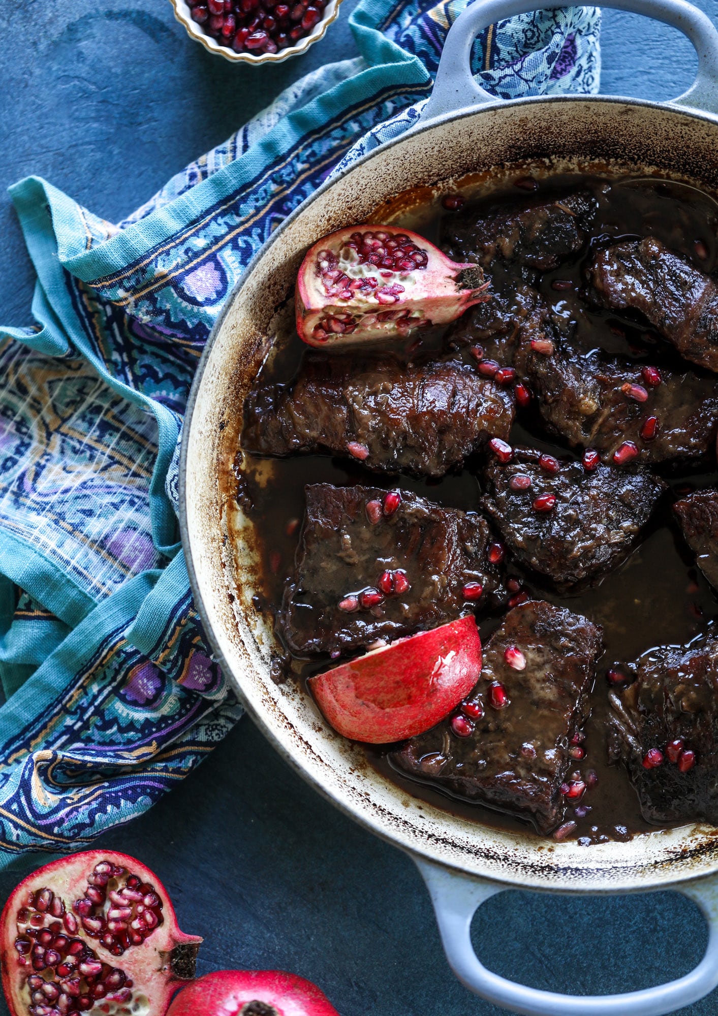 These pomegranate braised short ribs are an incredible take on comfort food! Pomegranate juice and molasses are the base of the recipe and after braising, you're left with tender, juicy and flavorful beef that is amazing served with polenta, potatoes or even in tacos. I howsweeteats.com #braised #shortribs