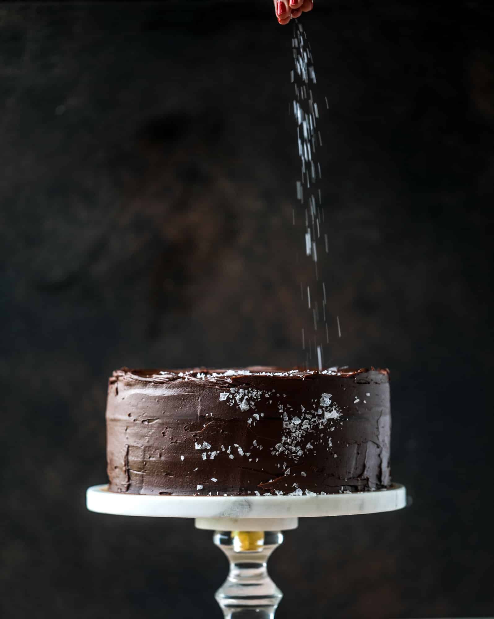 This salted dark chocolate stout cake is absolutely divine! It's ridiculously rich and perfect for a crowd or a party. Pumpkin stout batter is baked into fluffy laters and covered in a super fudgy chocolate ganache. Perfect for chocolate lovers! I howsweeteats.com #dark #chocolate #stout #cake #salted