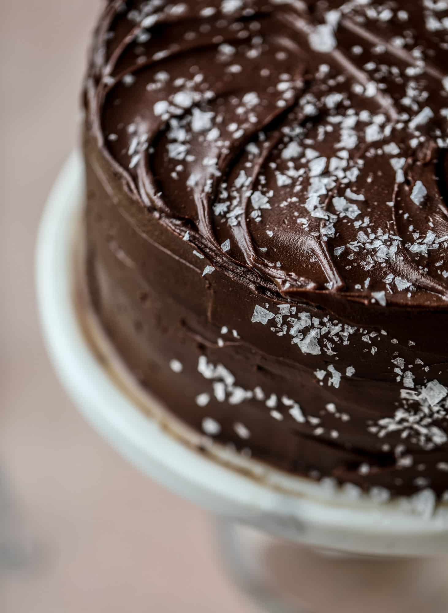 This salted dark chocolate stout cake is absolutely divine! It's ridiculously rich and perfect for a crowd or a party. Pumpkin stout batter is baked into fluffy laters and covered in a super fudgy chocolate ganache. Perfect for chocolate lovers! I howsweeteats.com #dark #chocolate #stout #cake #salted
