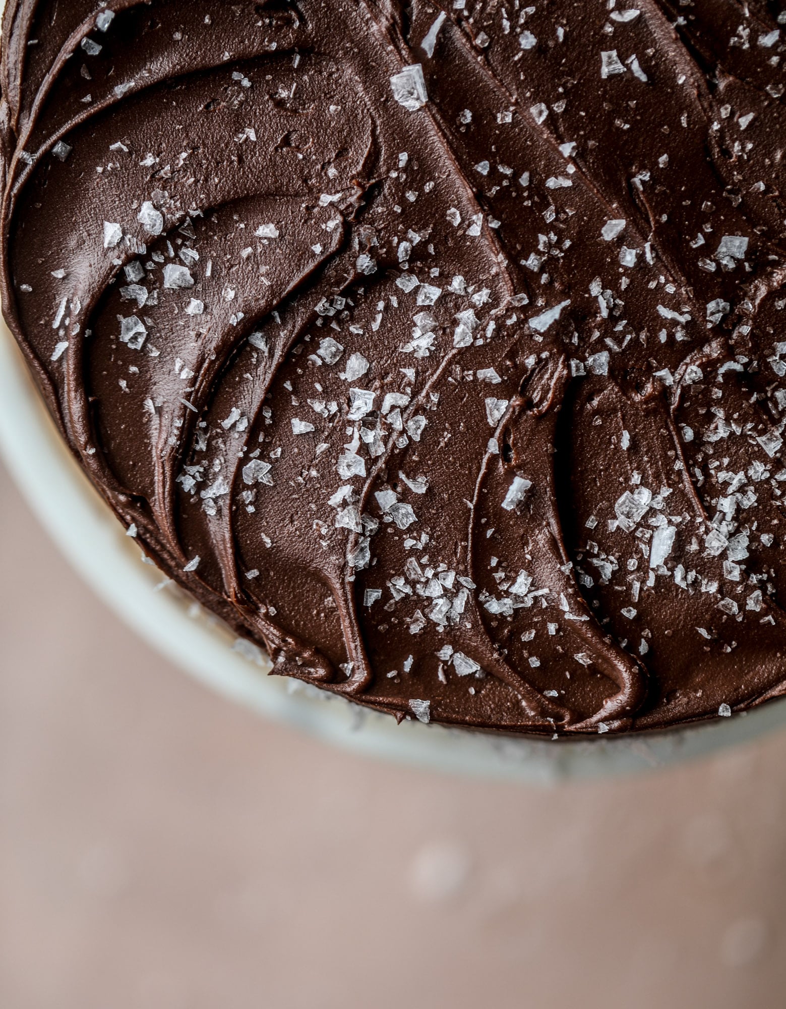 This salted dark chocolate stout cake is absolutely divine! It's ridiculously rich and perfect for a crowd or a party. Pumpkin stout batter is baked into fluffy laters and covered in a super fudgy chocolate ganache. Perfect for chocolate lovers! I howsweeteats.com #dark #chocolate #stout #cake #salted