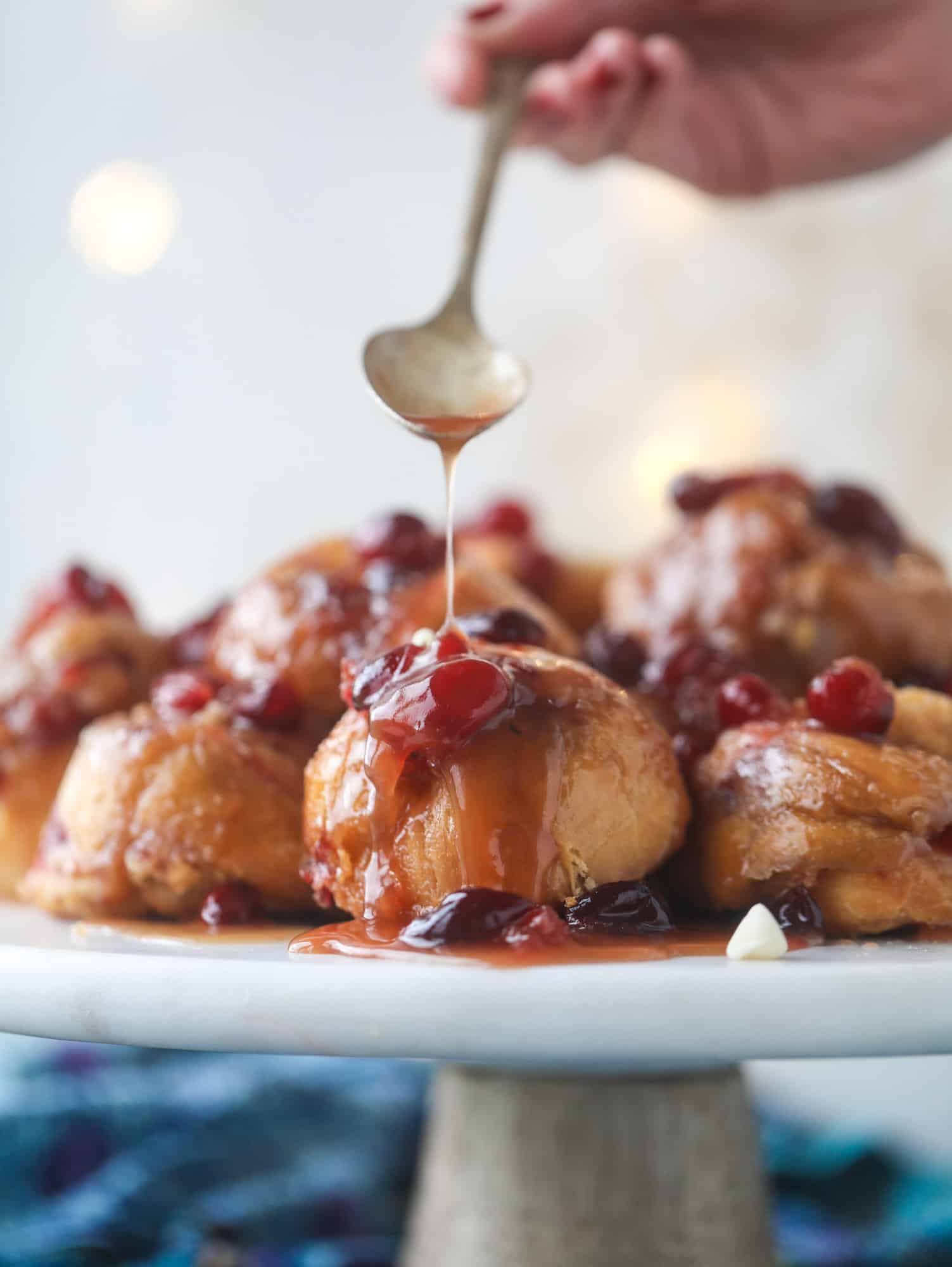 These white chocolate cranberry sticky buns are what holiday dreams are made of! Made in a muffin tin with fresh cranberries and creamy white chocolate, they are drizzled with cranberry caramel too! Dreamy! I howsweeteats.com #sticky #buns