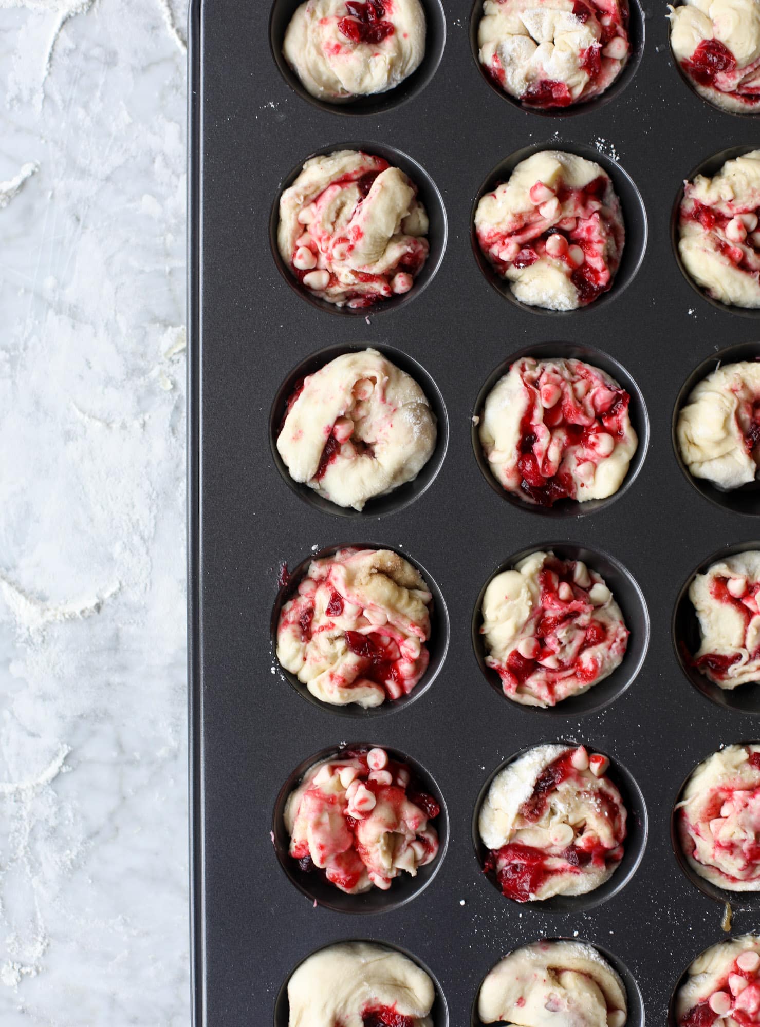 These white chocolate cranberry sticky buns are what holiday dreams are made of! Made in a muffin tin with fresh cranberries and creamy white chocolate, they are drizzled with cranberry caramel too! Dreamy! I howsweeteats.com #sticky #buns