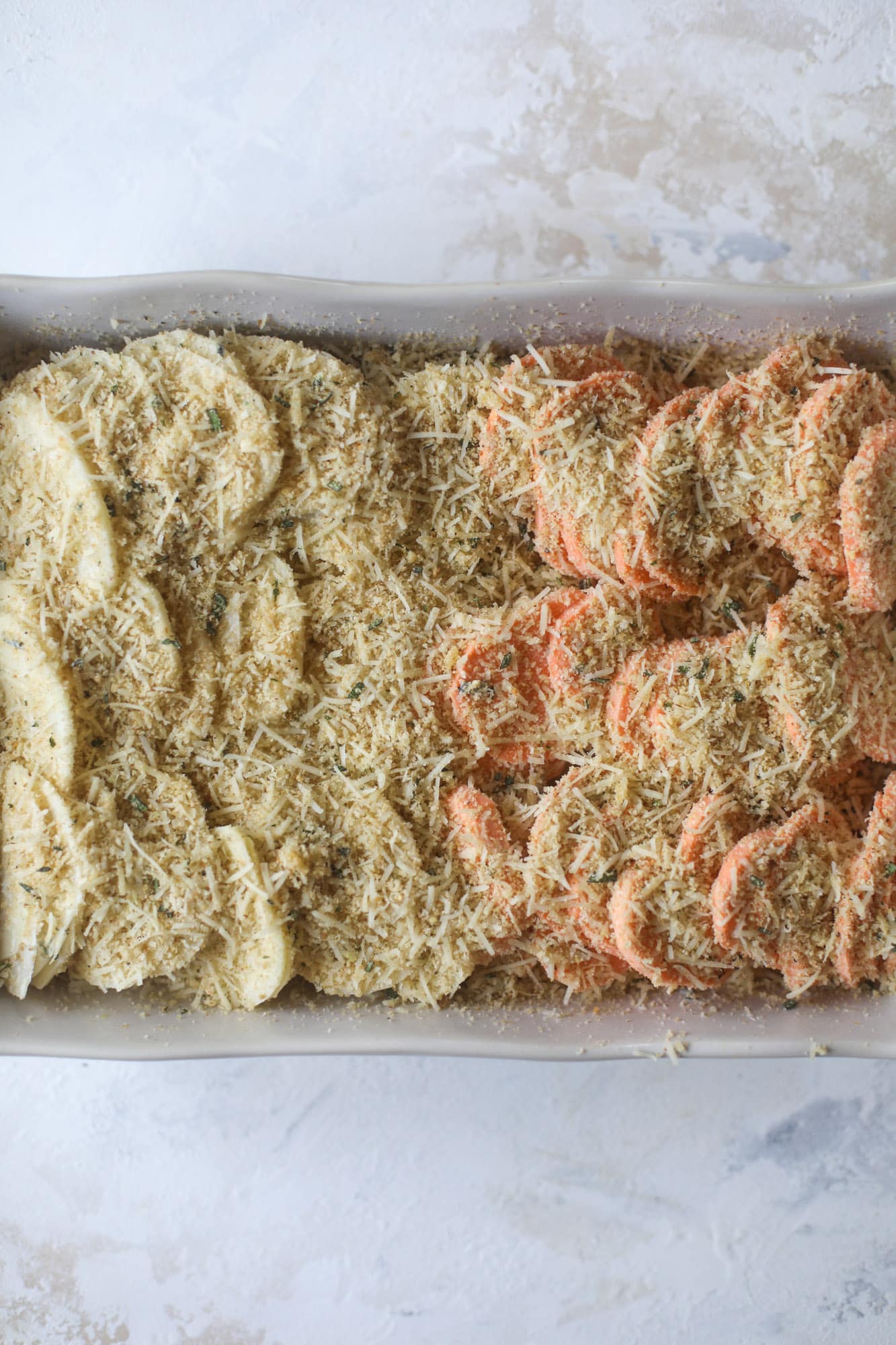 These scalloped potatoes are a cheese lover's dream. Sharp asiago and cream envelops idaho and sweet potatoes in these scalloped potatoes to please everyone! The crunchy asiago topping is irresistible. I howsweeteats.com #scalloped #potatoes