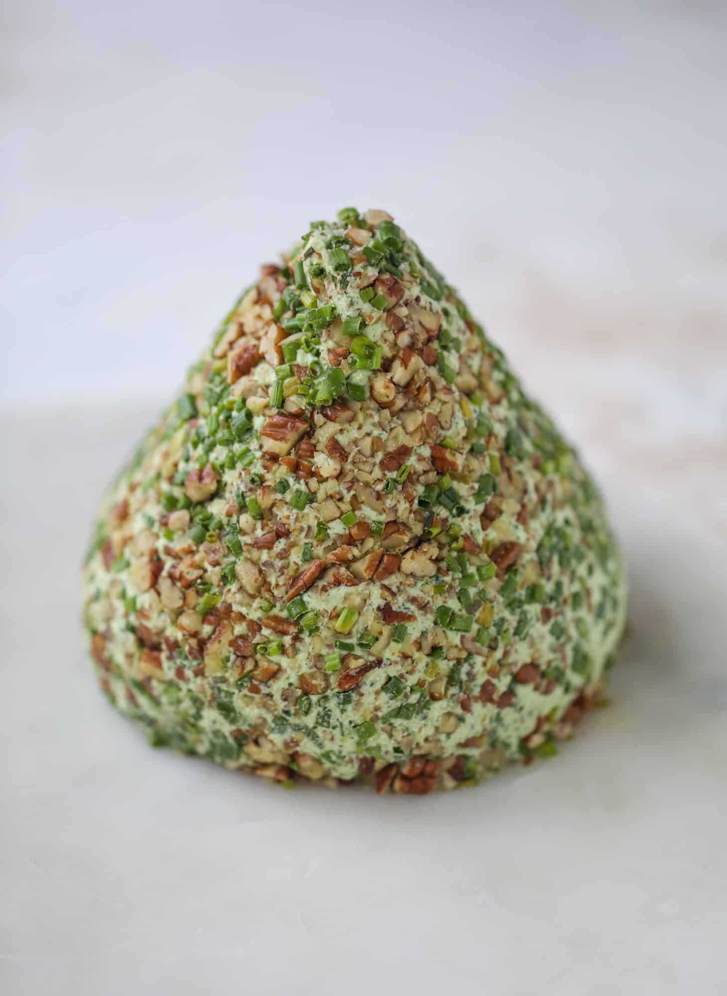 This green goddess cheese ball is the perfect party snack! You can make it ahead of time and shape it into a cute tree for a festive look. Serve it with crispy crackers and pita chips! I howsweeteats.com #greengoddess #cheeseball