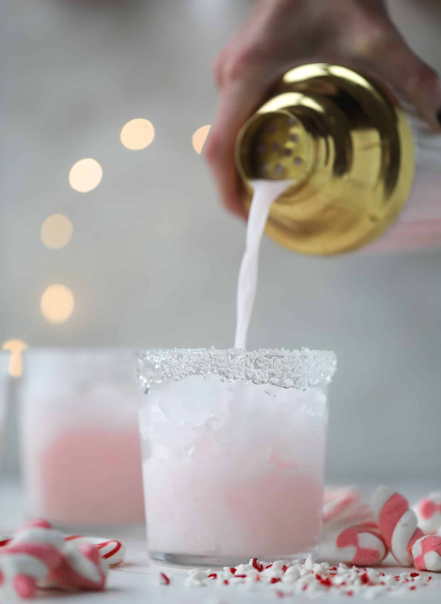 This pink peppermint cocktail is full of holiday cheer! Candy cane vodka, creme de cacao, vanilla and a drop of cream come together to create the perfect iced holiday drink that tastes like a treat! I howsweeteats.com #pinkpeppermint #cocktail