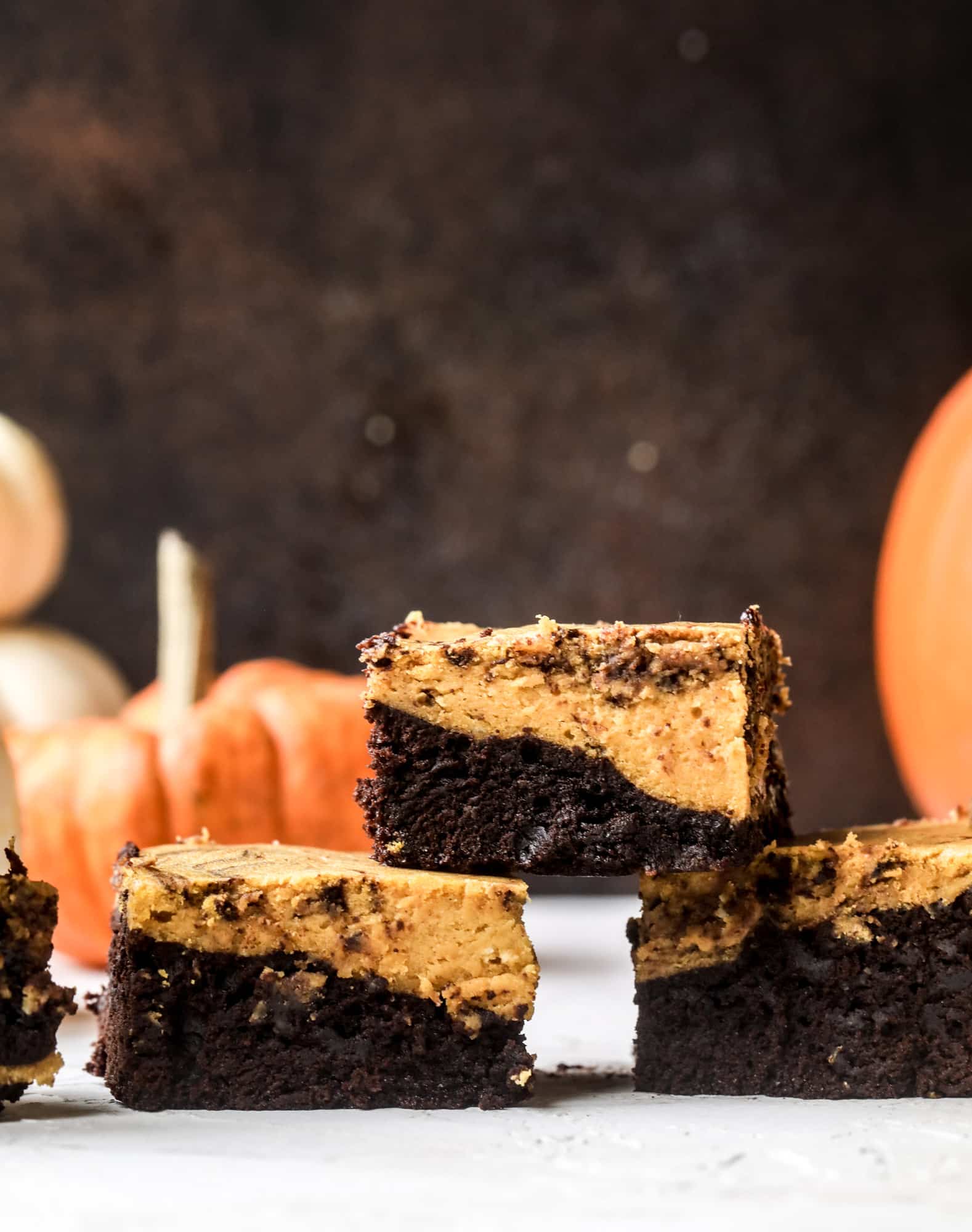 These pumpkin brownies have a fudgy layer of chocolate on the bottom and a silky layer of pumpkin on top! They are so delicious and rich and perfect for fall. The pumpkin brownies come together easily and can be made ahead of time too! I howsweeteats.com #pumpkin #brownies