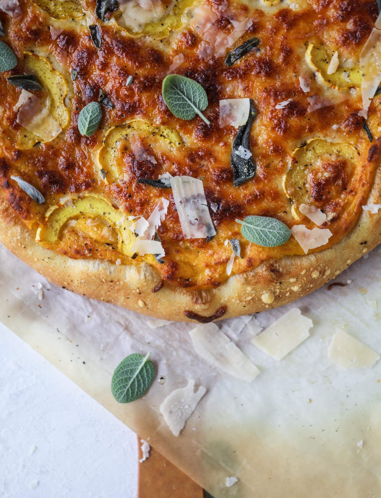 This butternut squash pizza has all the perfect tastes of fall in a pizza! Creamy butternut squash base, sharp parmesan cheese, crispy, fresh sage - it's all these and so super flavorful. It's easy too! I howsweeteats.com #butternutsquash #pizza
