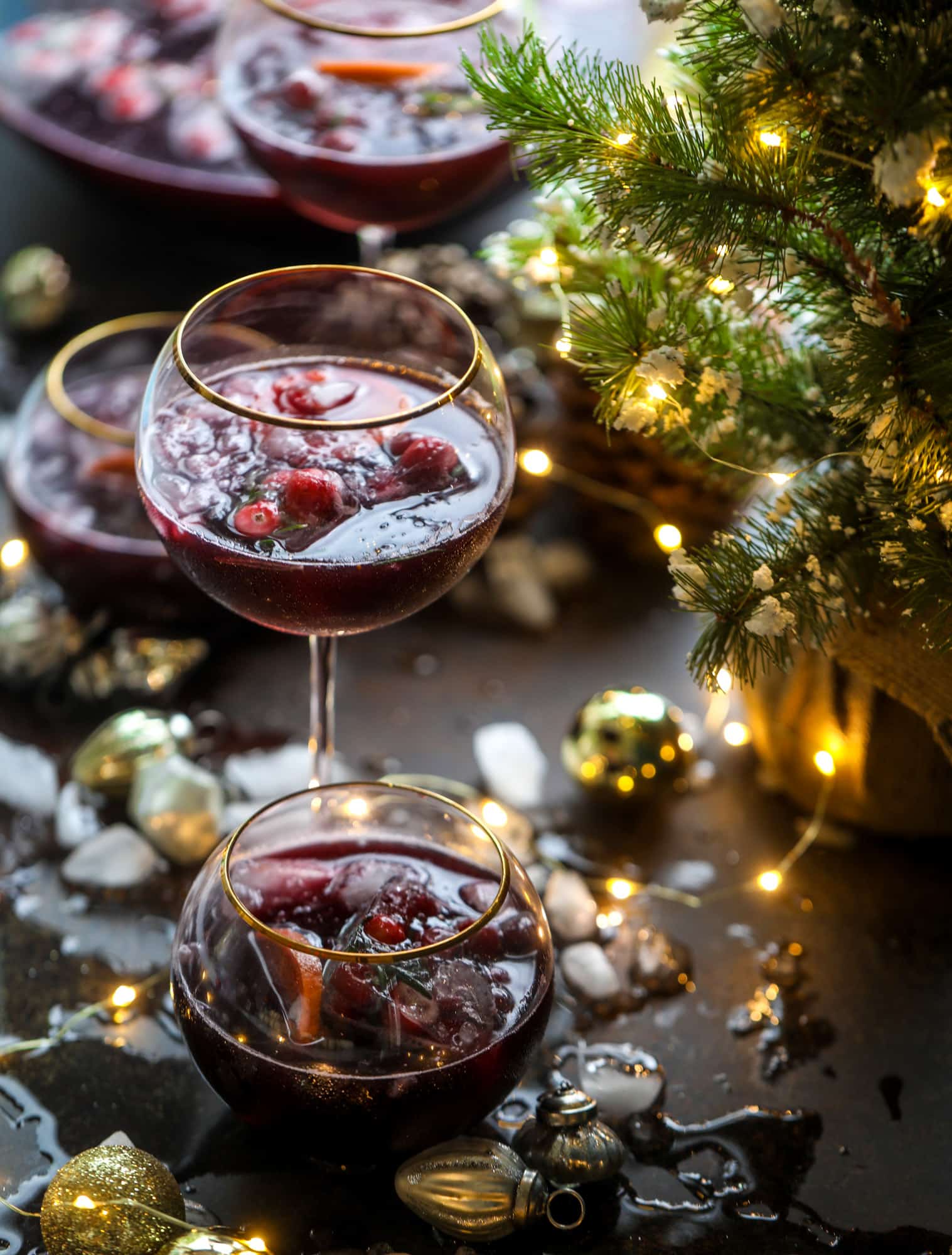 This tree trimming punch is the most perfect christmas punch to drink while decorating the tree! Rich red wine is the base and there's a bit of orange, some spice, cinnamon and a gorgeous jeweled holiday ice cubes! I howsweeteats.com #christmas #punch