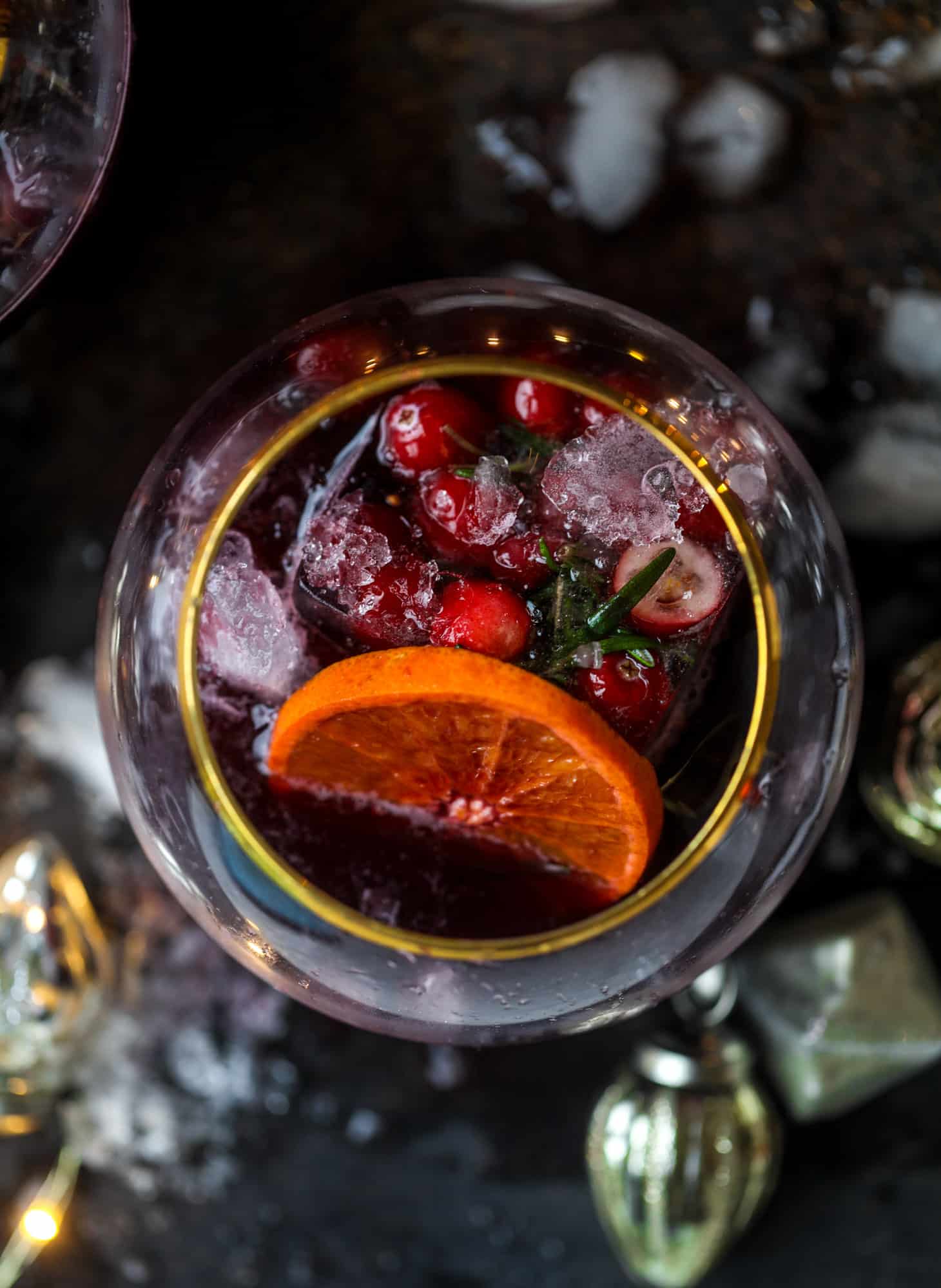 This tree trimming punch is the most perfect christmas punch to drink while decorating the tree! Rich red wine is the base and there's a bit of orange, some spice, cinnamon and a gorgeous jeweled holiday ice cubes! I howsweeteats.com #christmas #punch