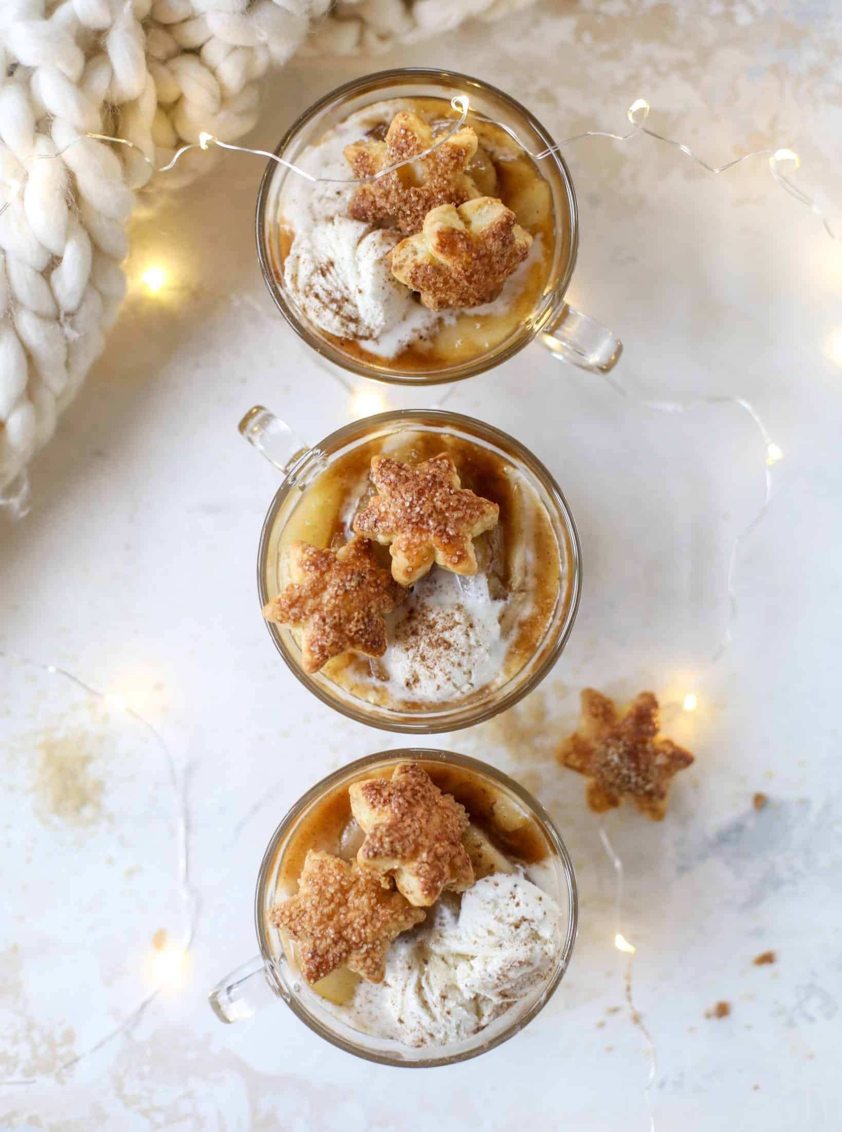 This pear mug pie is the coziest way to enjoy warm, caramelized pears. Topped with vanilla ice cream and the cutest, quick puff pastry stars, these are a great dessert for a dinner party or an easy one to make for yourself on a Saturday night! I howsweeteats.com #pear #mugpie