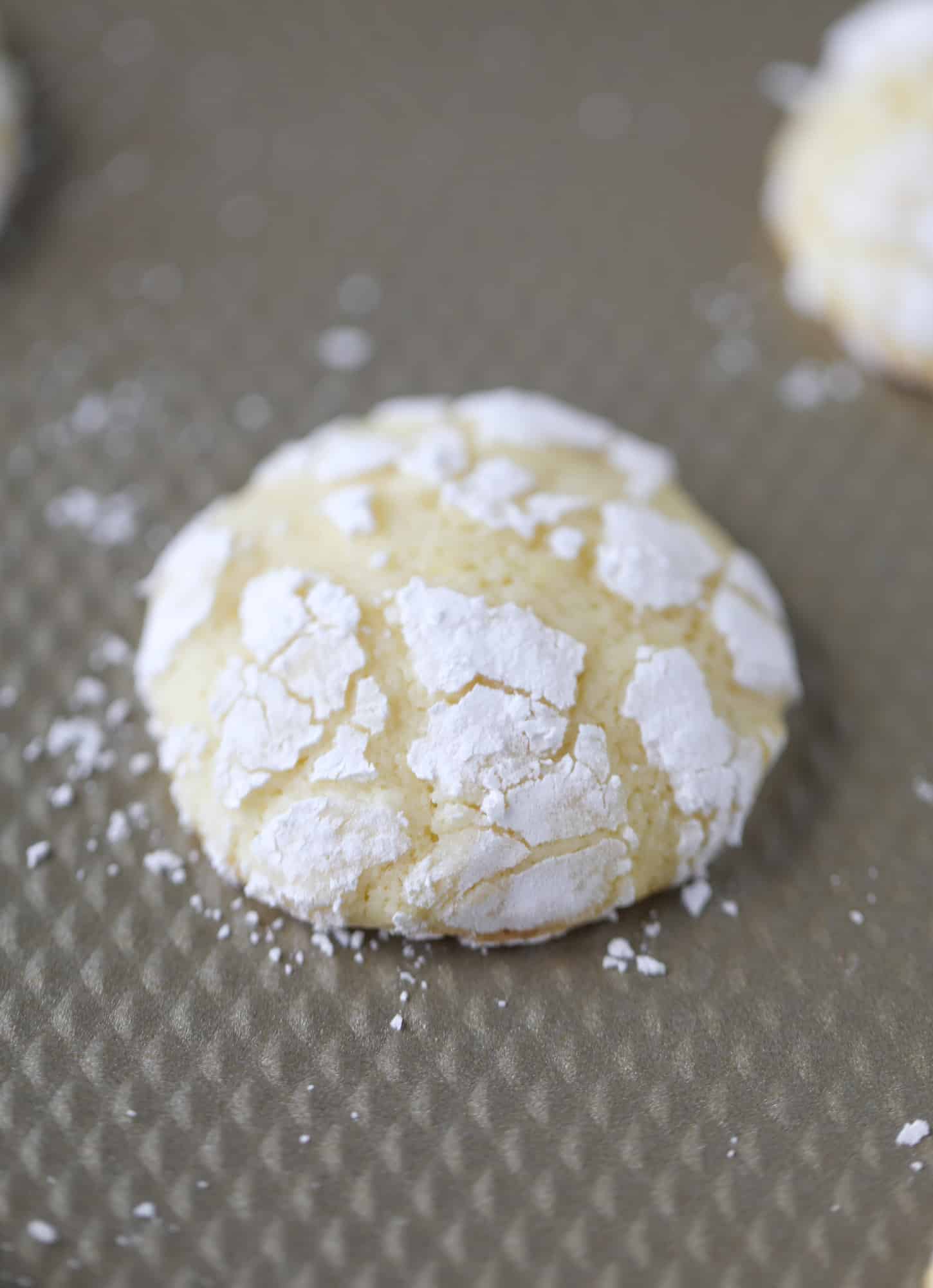 These lemon crinkle cookies are perfect if you love lemon desserts! They take after chocolate crinkle cookies, but are a delightful refreshing lemon flavor sprinkle with powdered sugar. These are always a huge hit! I howsweeteats.com #lemoncrinkle #cookies