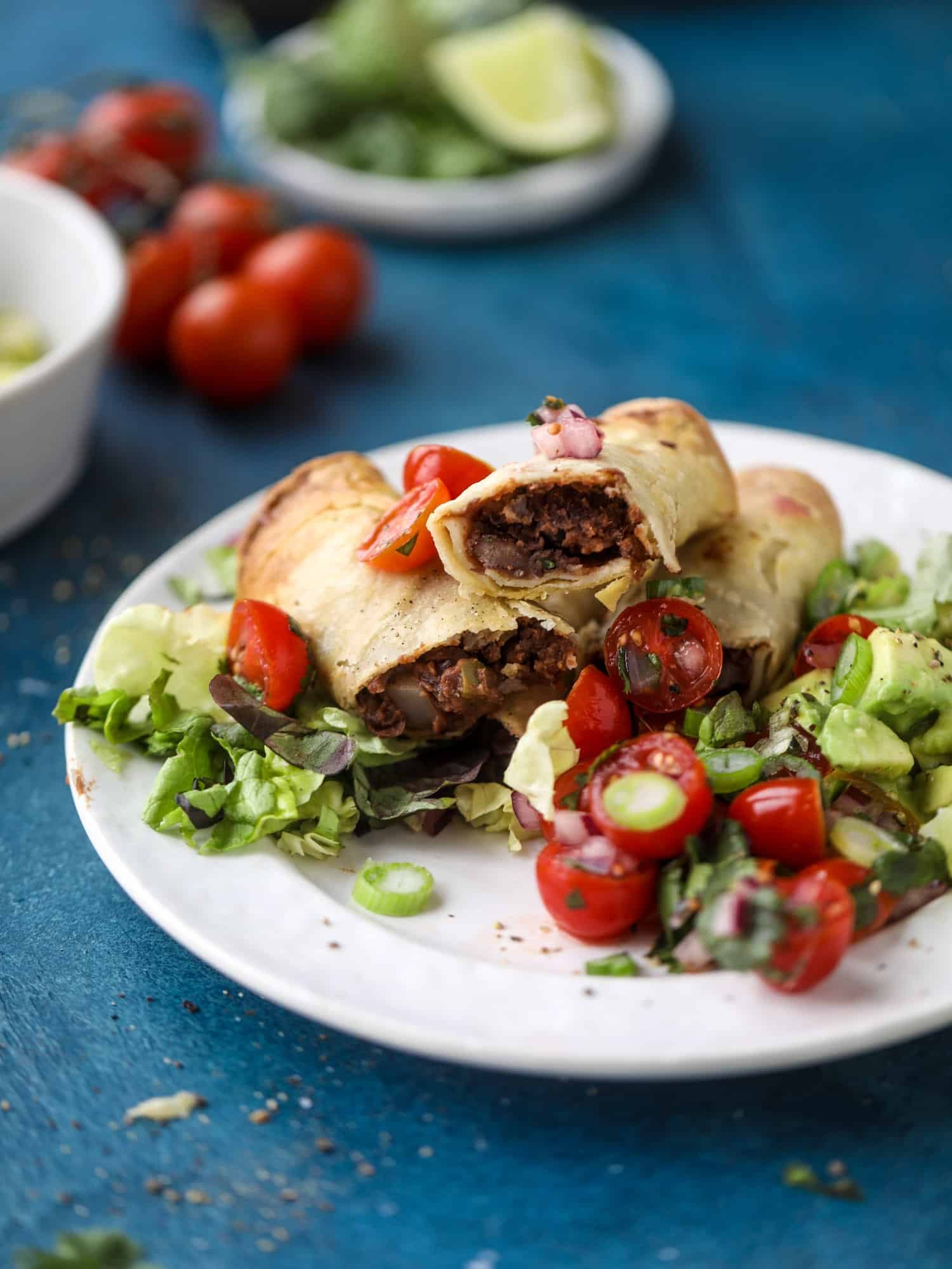 Saucy baked black bean taquitos have a crunchy outside and a creamy, flavorful inside. Served with a pico de gallo, they are an easy weeknight meal! I howsweeteats.com #baked #taquitos