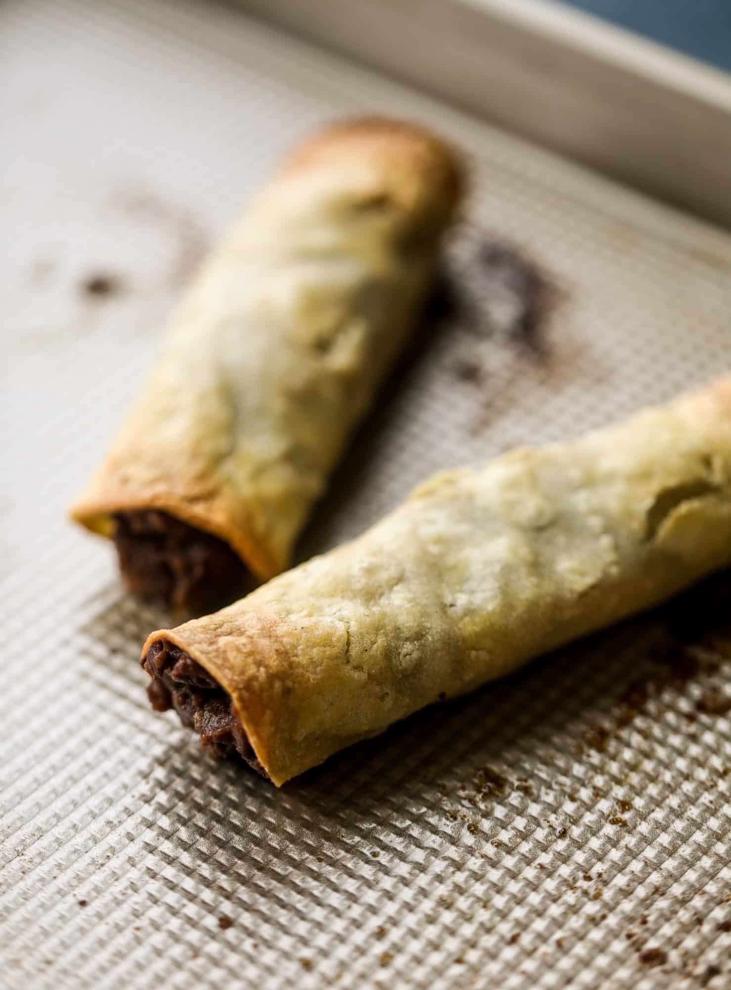 Saucy baked black bean taquitos have a crunchy outside and a creamy, flavorful inside. Served with a pico de gallo, they are an easy weeknight meal! I howsweeteats.com #baked #taquitos