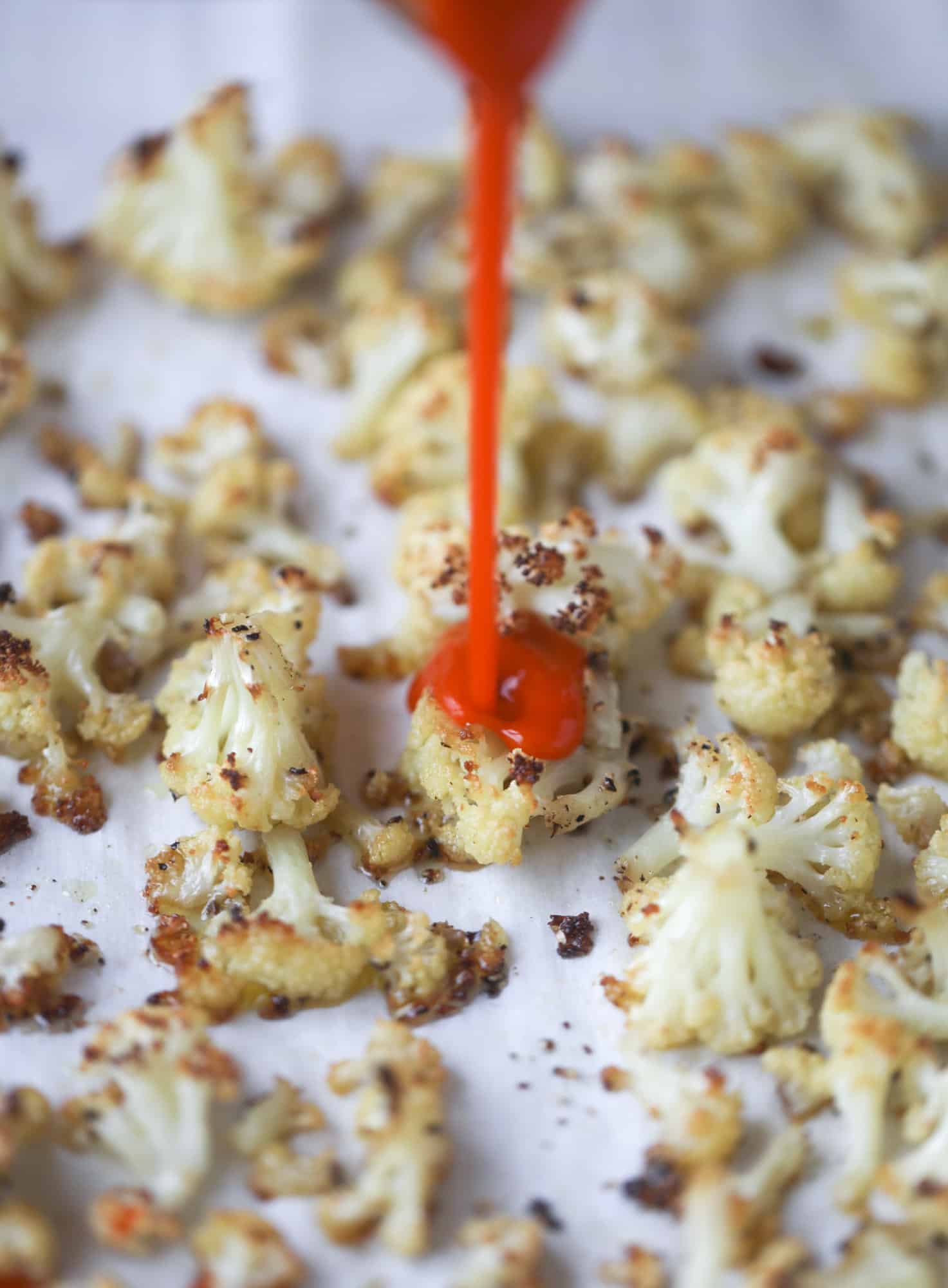 These buffalo cauliflower lettuce wraps are perfect for game day or even a quick weeknight dinner. Roasted cauliflower with buffalo wing sauce, sliced avocado, crumbled blue cheese, scallions, cilantro and chives makes for a flavor explosion! I howsweeteats.com #buffalo #cauliflower