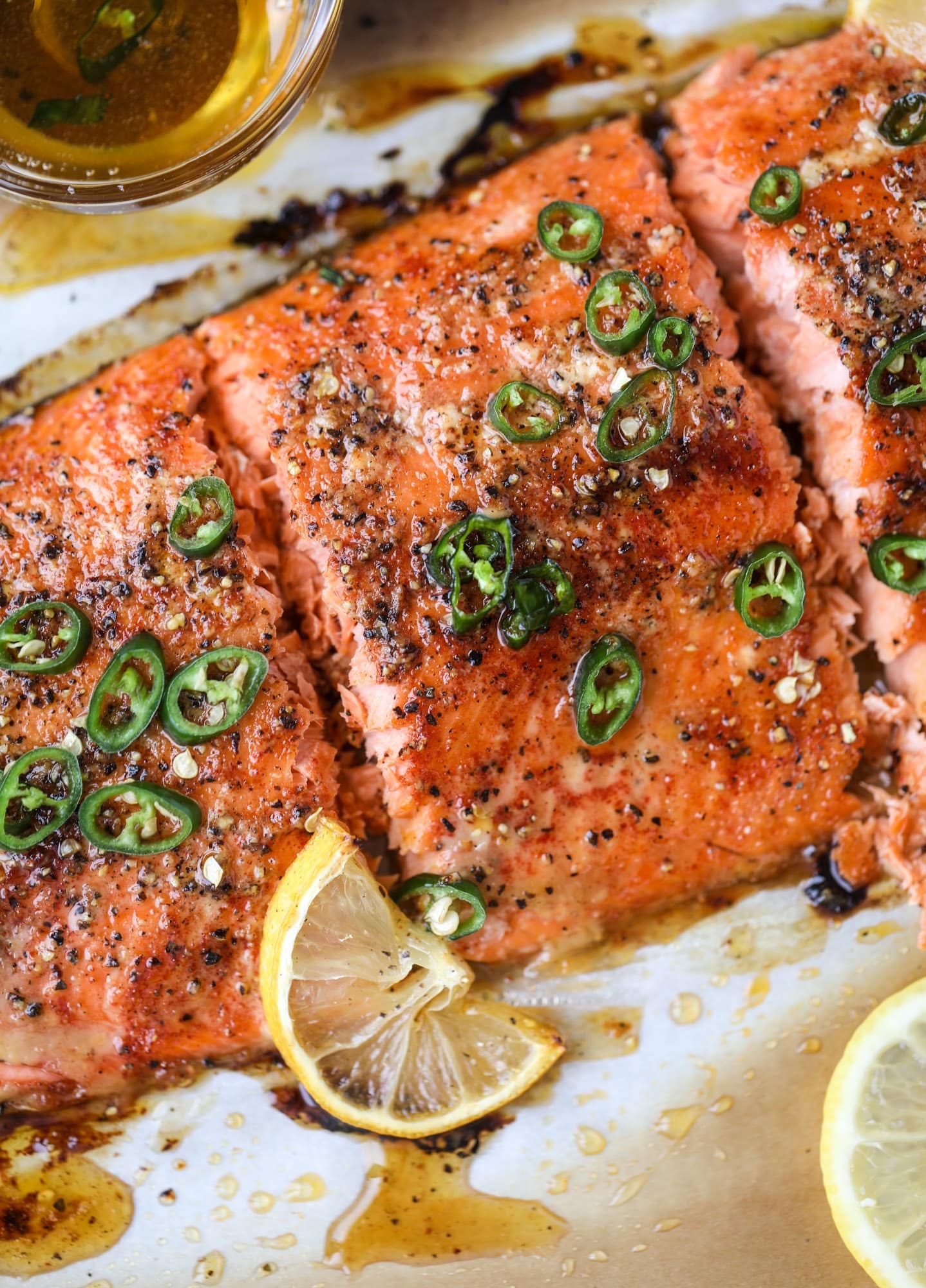 This hot honey salmon is flakey and buttery with a hint of heat and a sprtiz of lemon. It's an easy weeknight meal and is delicious on salads for lunch! I howsweeteats.com #hothoney #salmon